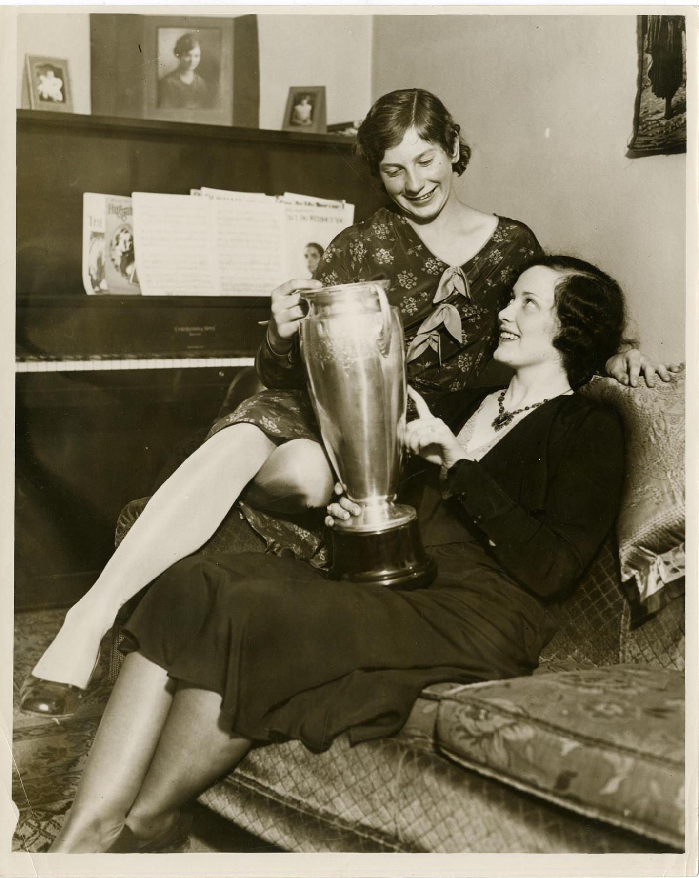 Image of Helene Madison showing another woman a swimming trophy, March 1930