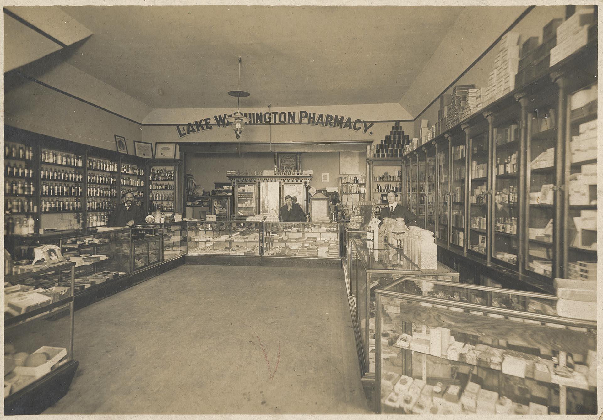Image of Three men behind counter at Lake Washington pharmacy, Seattle, circa 1905
