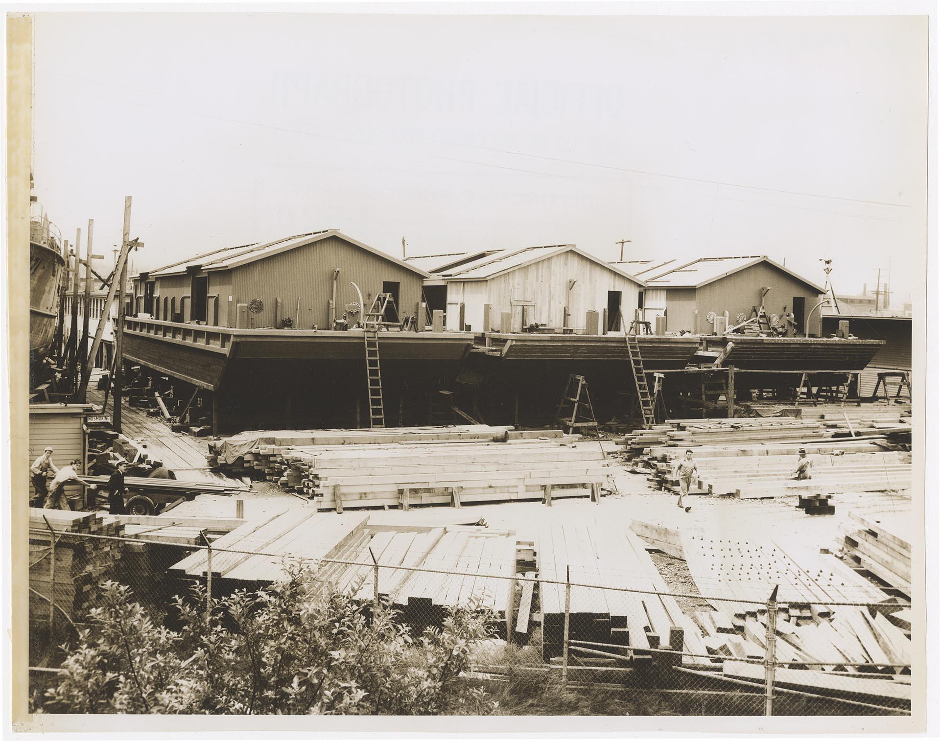 Image of U.S. Navy covered wooden lighters under construction at the Olson & Winge Marine Works yard, Seattle, 1943
