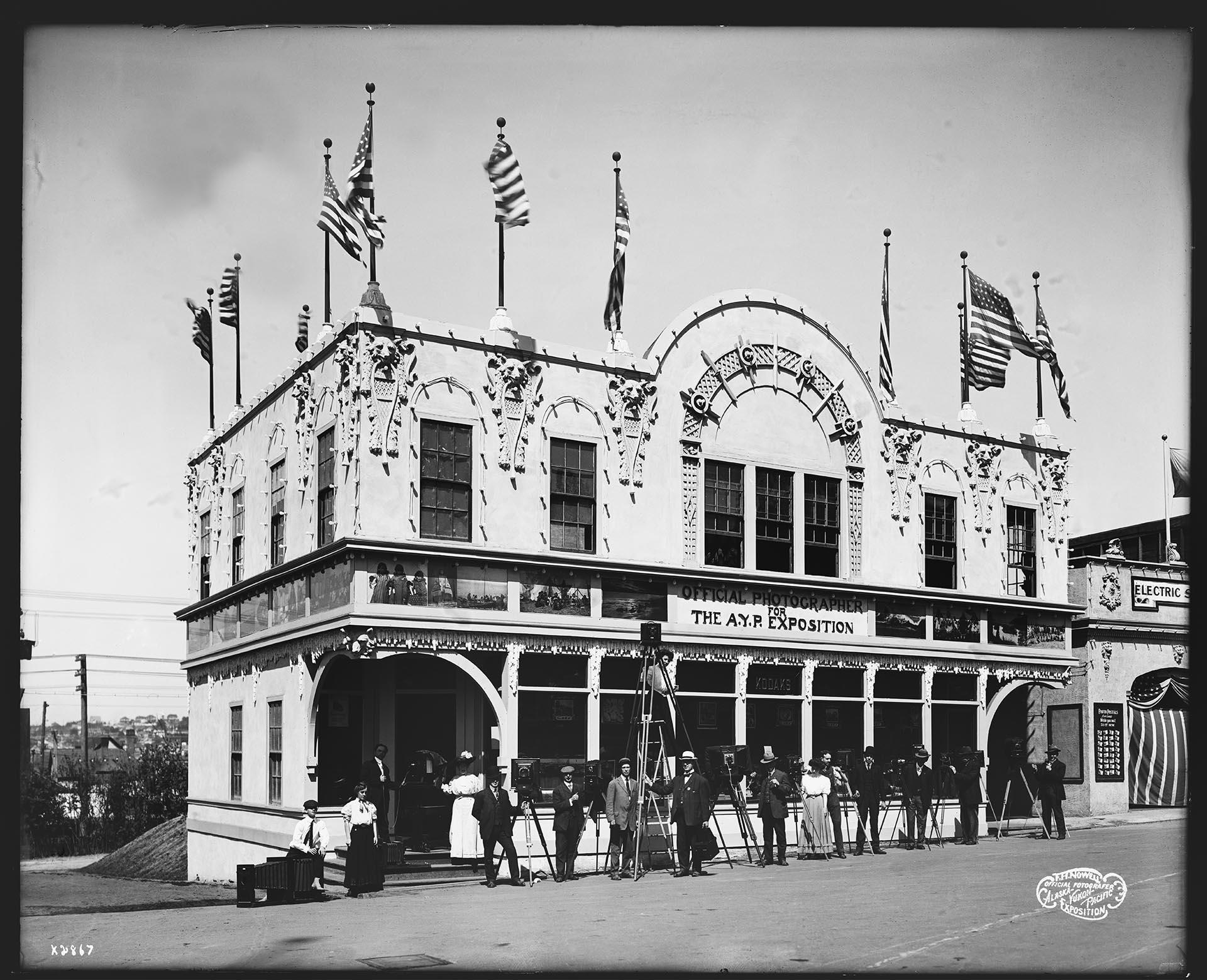 Image of Photographers posing in front of the Photographic Building at the Alaska-Yukon-Pacific Exposition, 1909