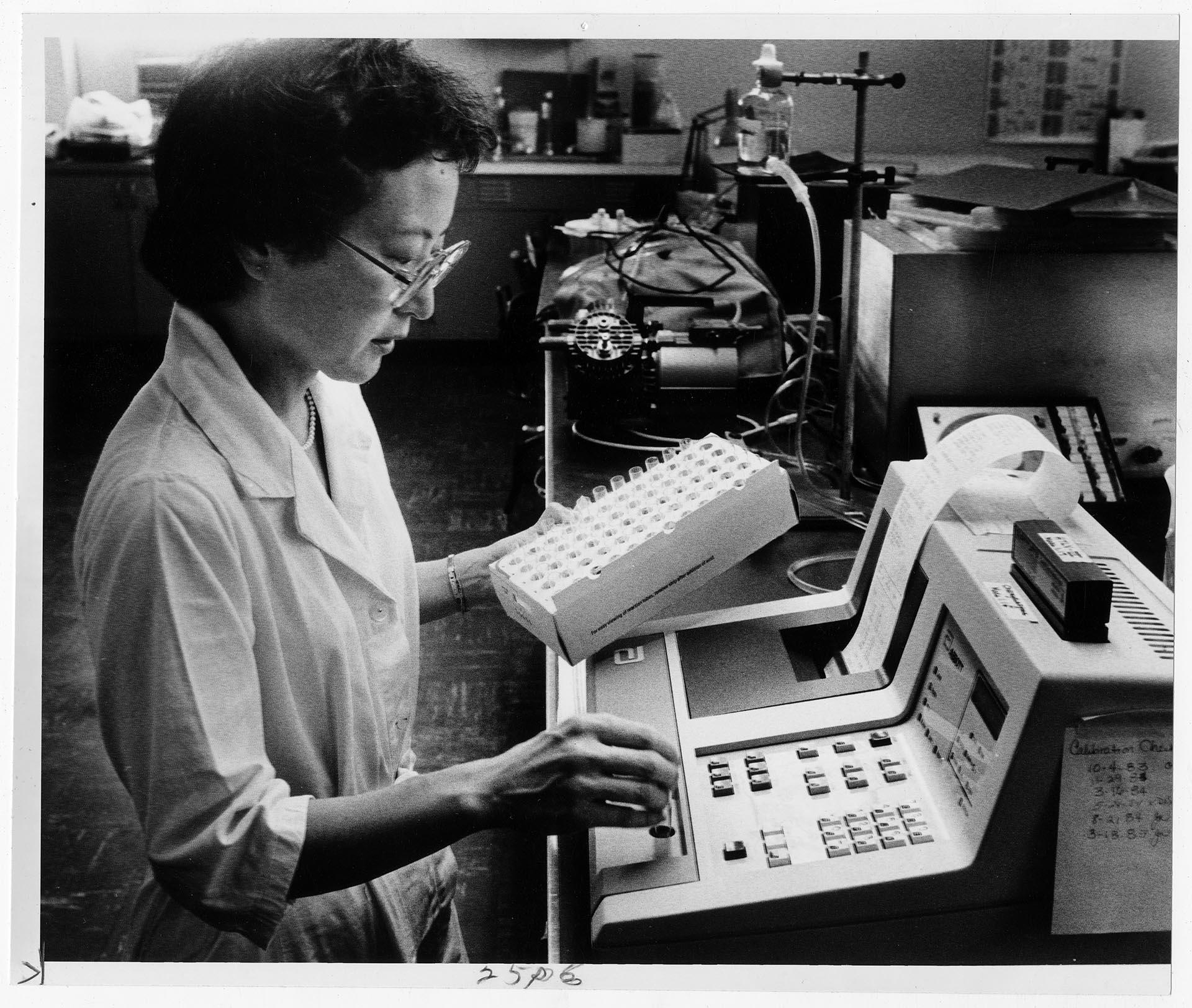 Image of Woman running AIDS computer test on vials of blood, Seattle, August 16, 1985
