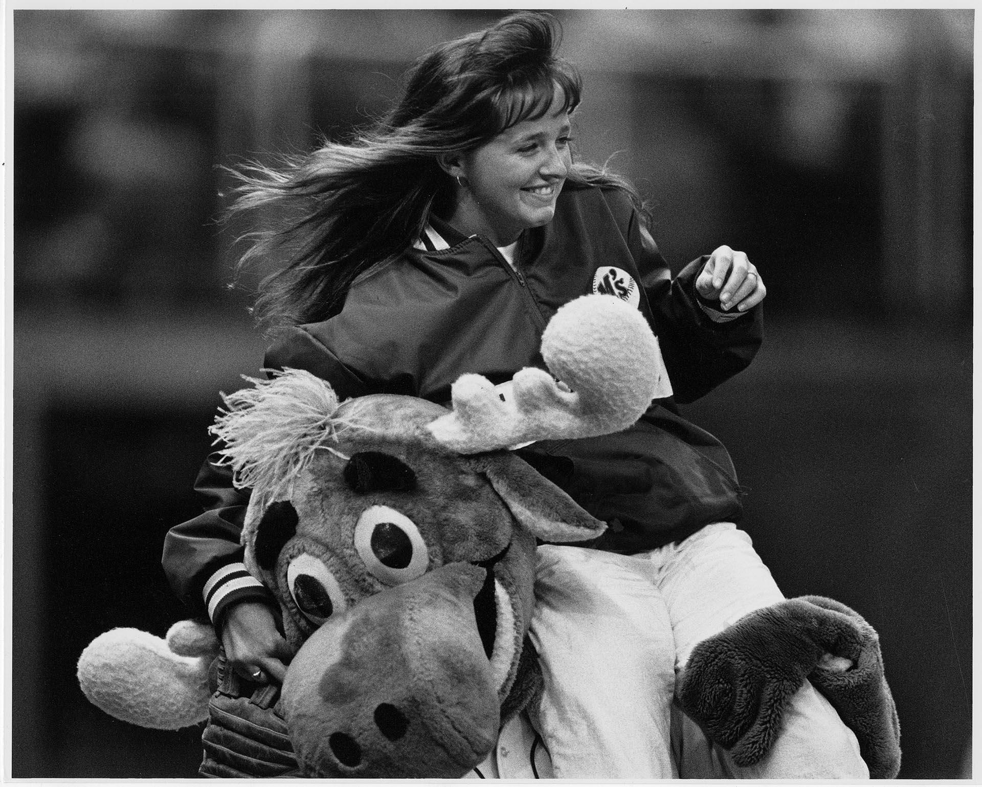 Image of Mariner Moose carrying Amy Martin around infield at the Kingdome, April 16, 1990
