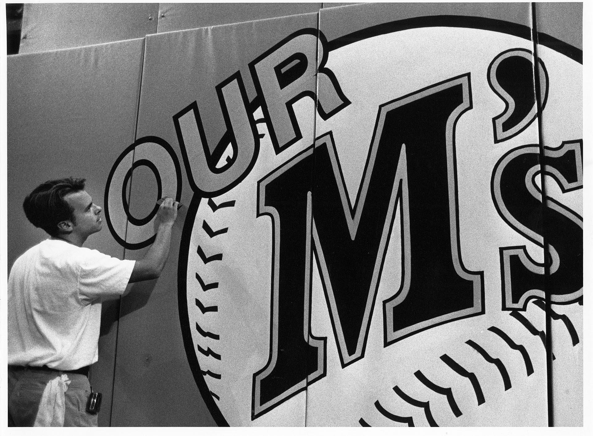 Image of Mark Popich working on Mariner's sign at stadium, July 16, 1992