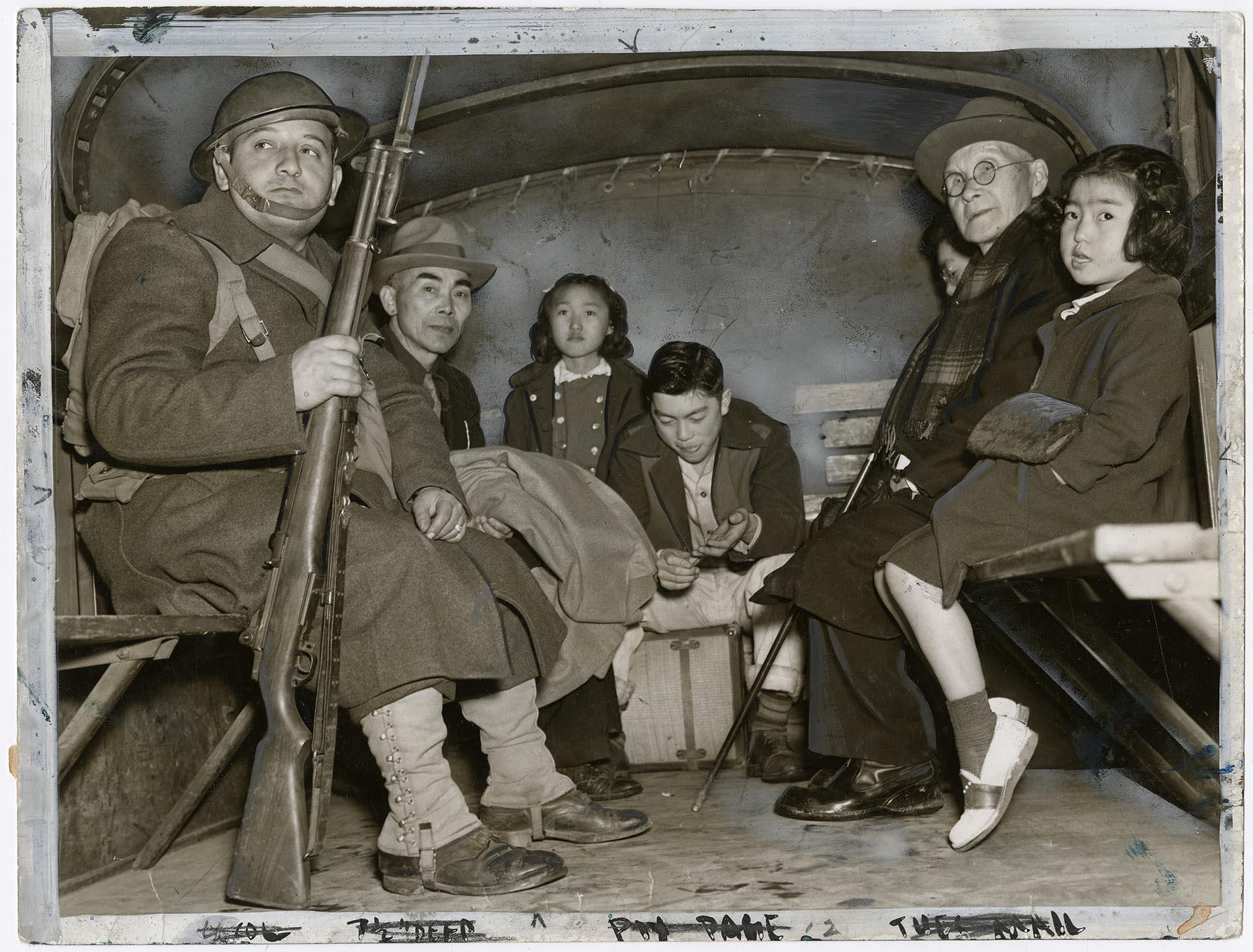 Image of Japanese Americans from Bainbridge Island in back of military truck, March 31, 1942