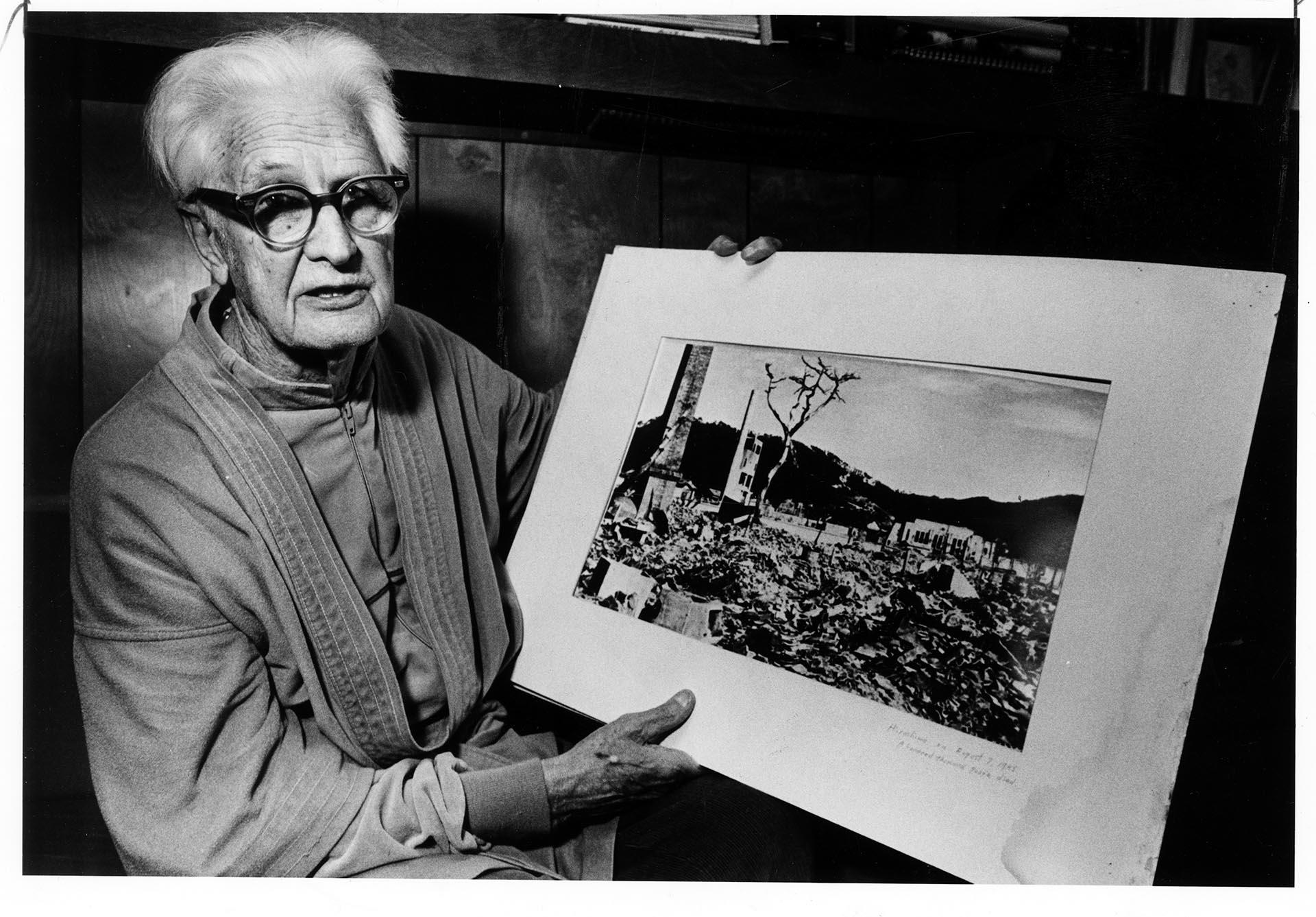 Image of Floyd Schmoe with photo of Hiroshima, November 20, 1983