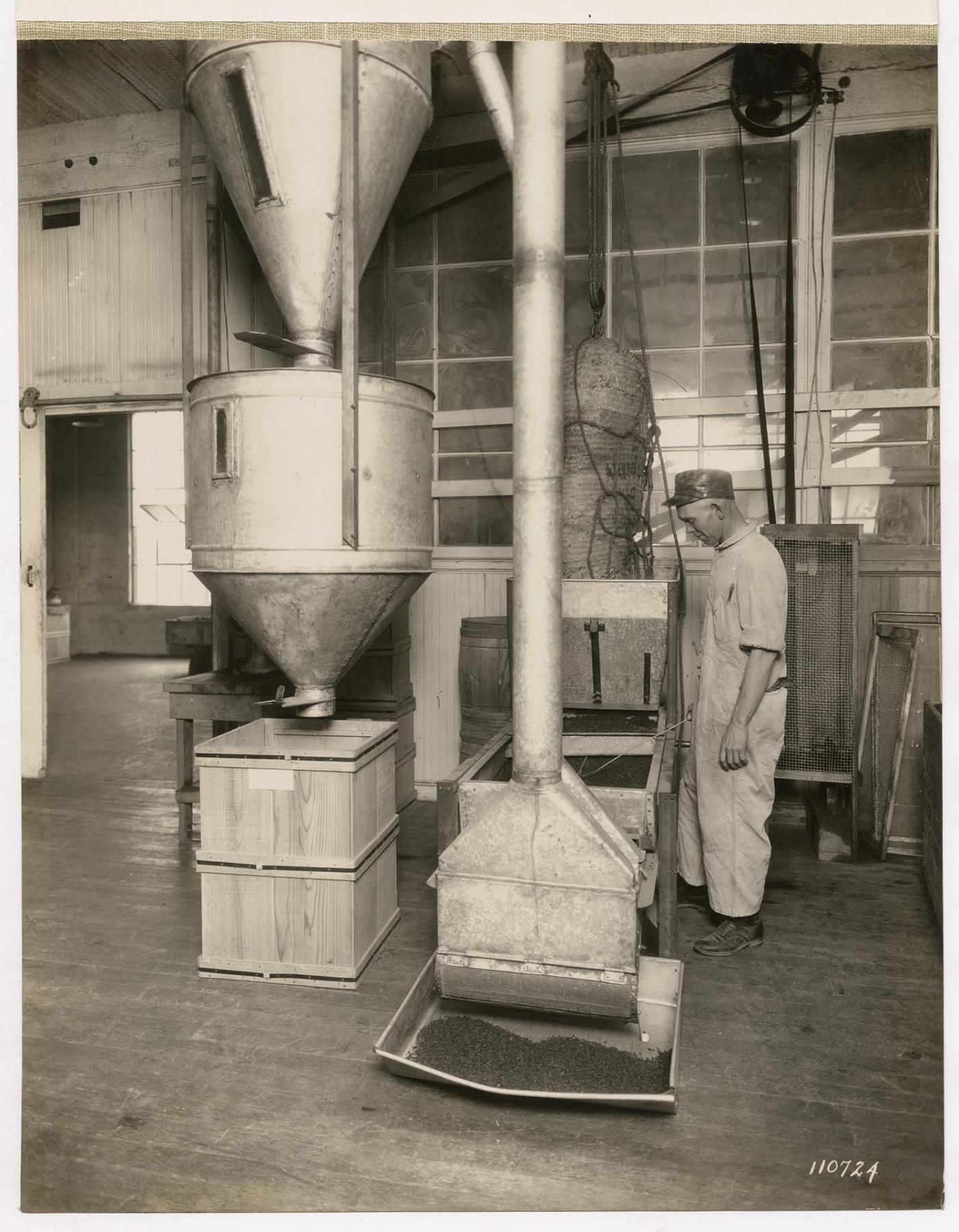 Image of Employee operating a spice cleaning apparatus at the Crescent Manufacturing Company, Seattle, circa 1923