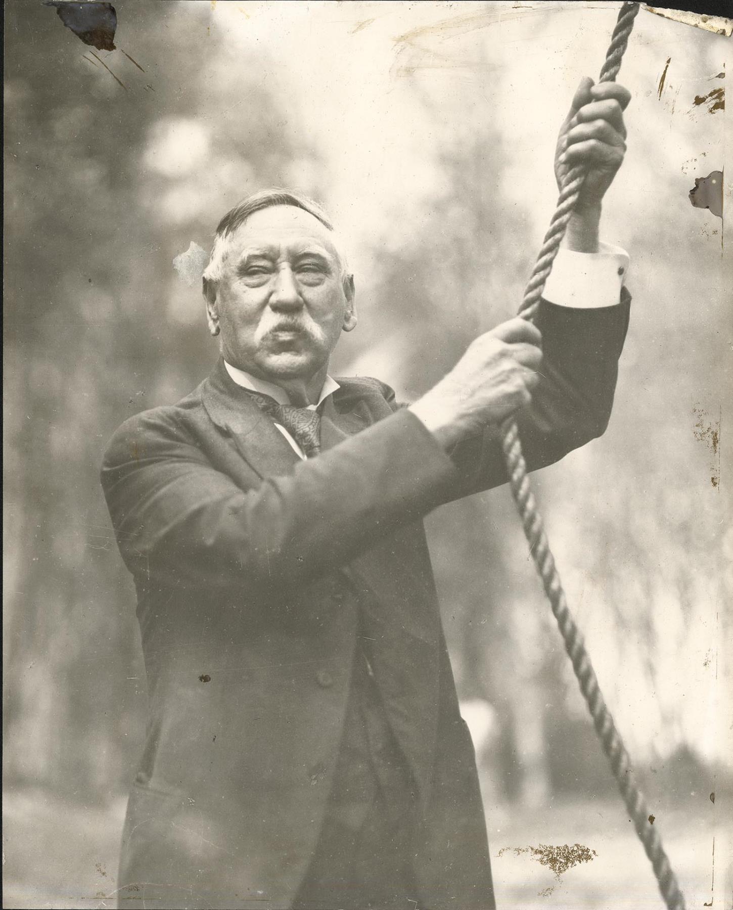 Image of Morgan J. Carkeek ringing bell, Carkeek Park, Seattle, circa 1920