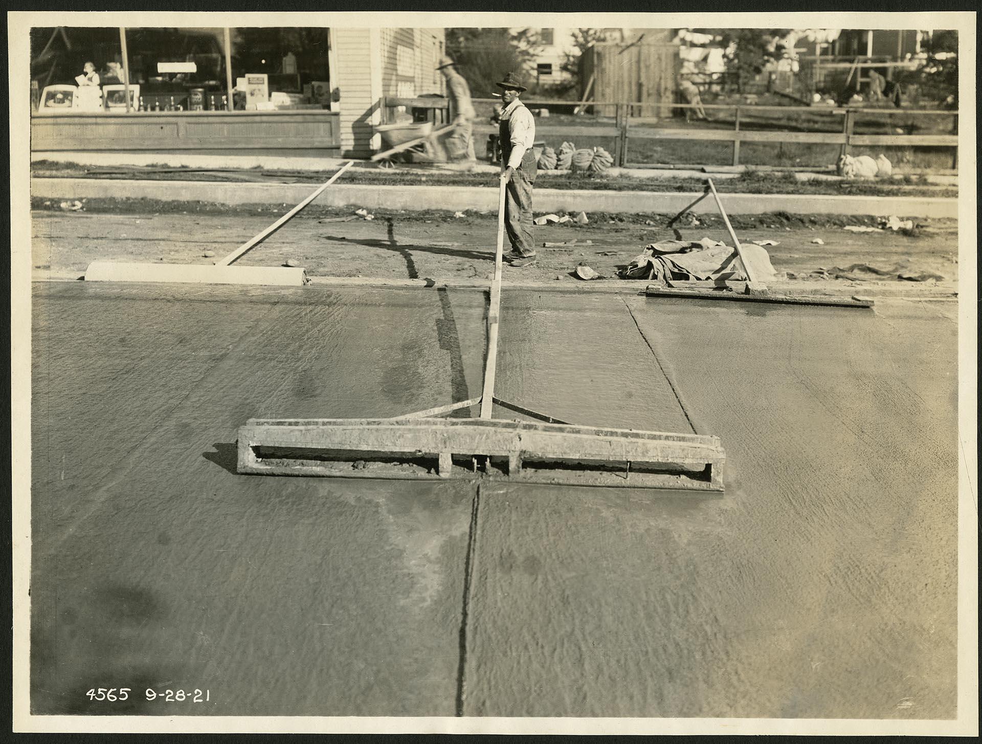 Image of Man smoothing wet concrete on 10th Avenue NE, Seattle, September 28, 1921