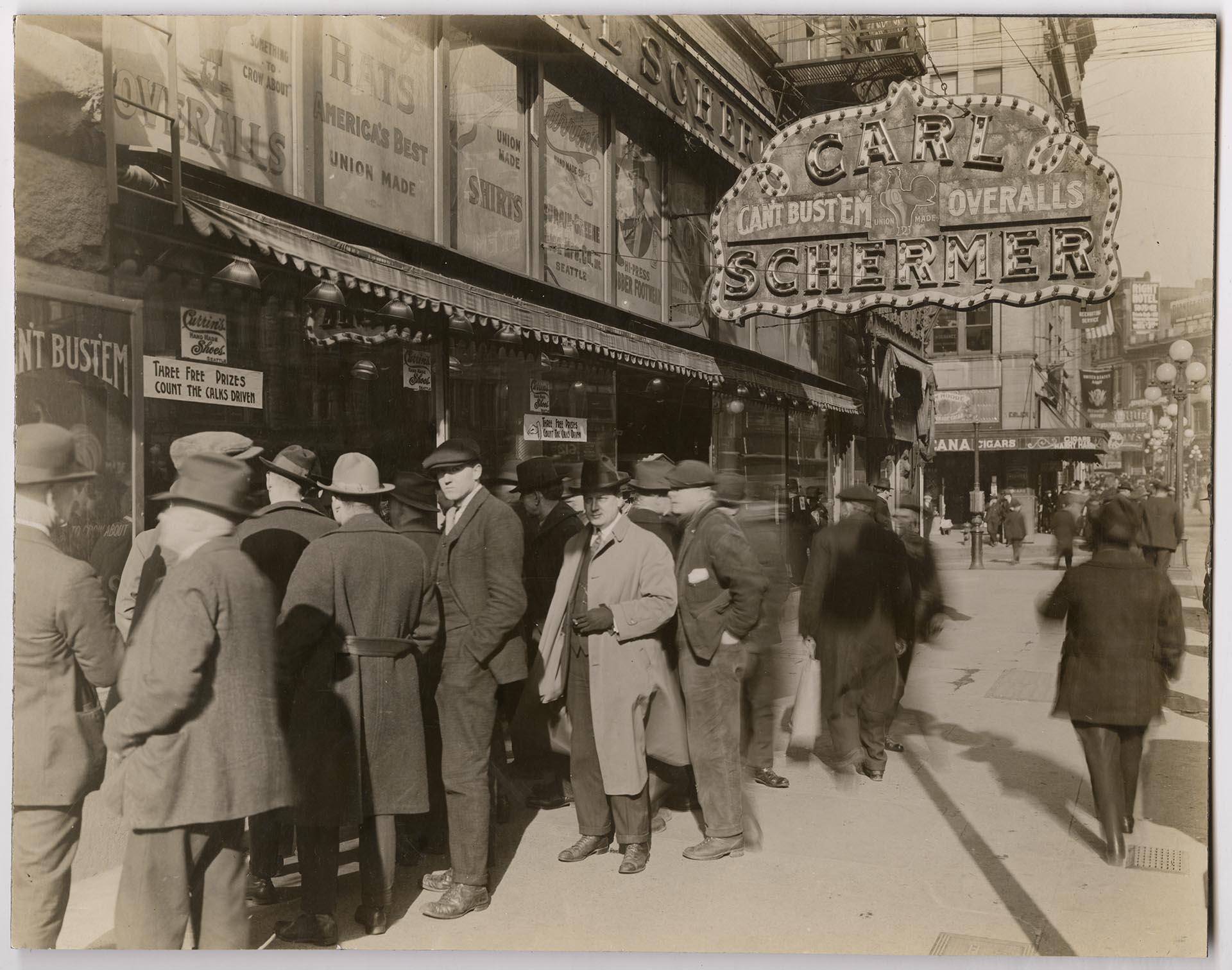 Image of Group of men looking at Currin shoe window display in Carl Schermer store, First Avenue South, Seattle, 1921