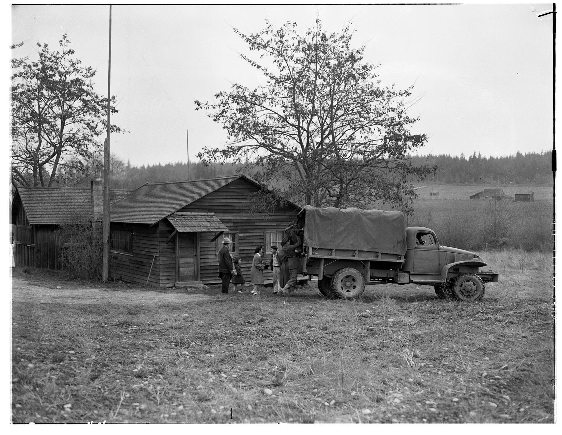 Image of U. S. soldiers and Nakamura family loading Army truck for forced removal, Bainbridge Island, March 30, 1942