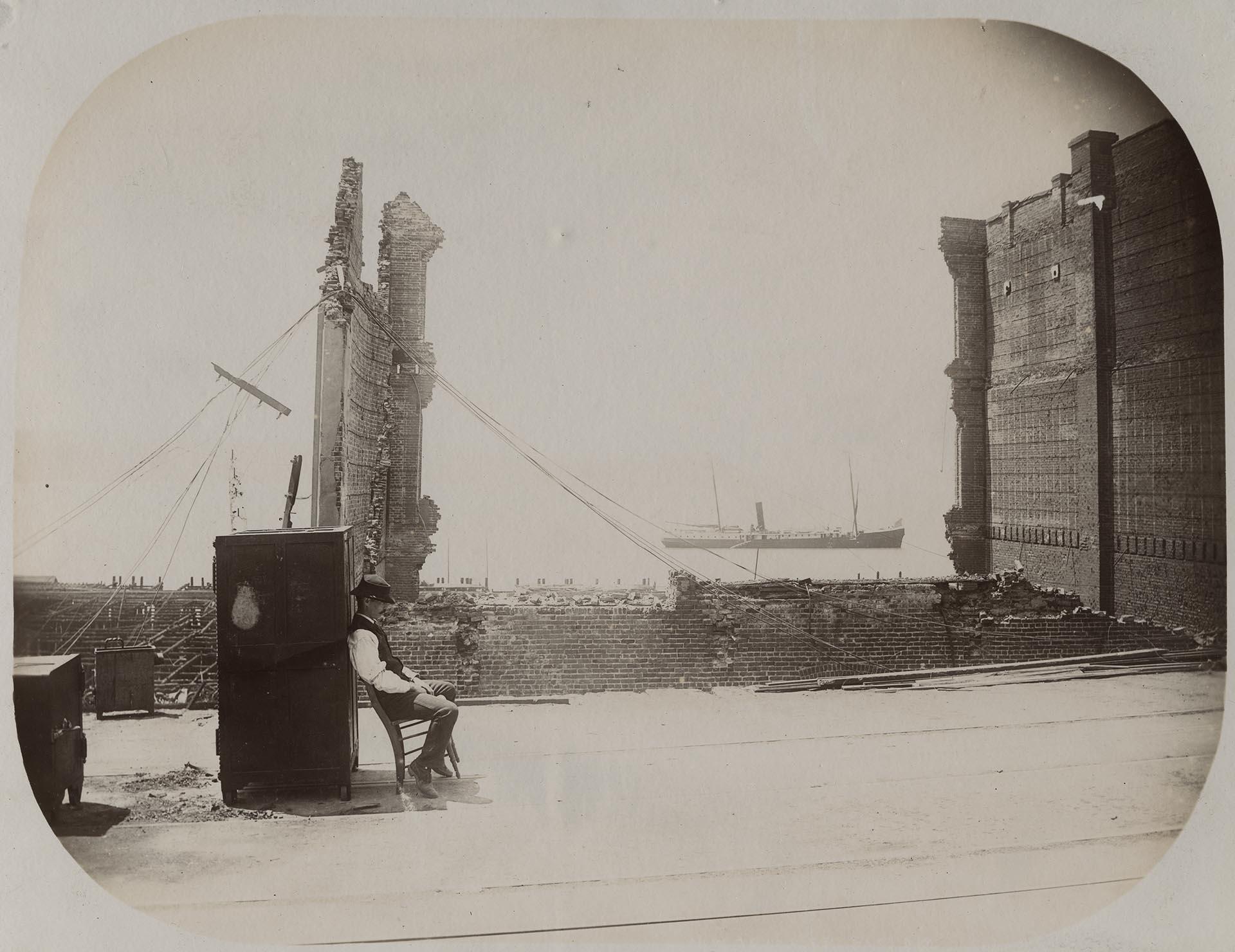 Image of Man guarding a safe after Great Seattle Fire, June 6, 1889