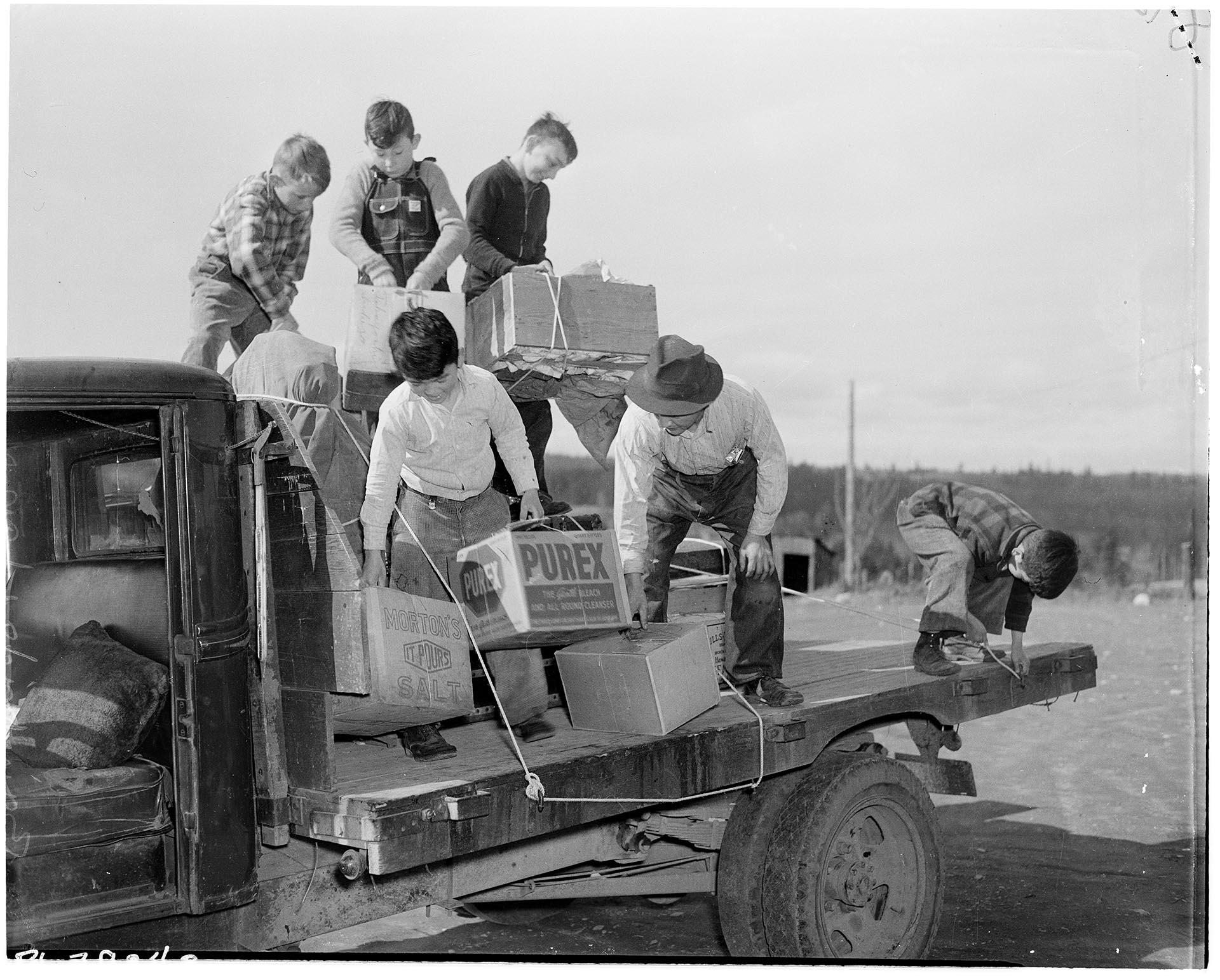 Image of Boys helping Japanese American man load truck for forced removal, Bainbridge Island, March 30, 1942