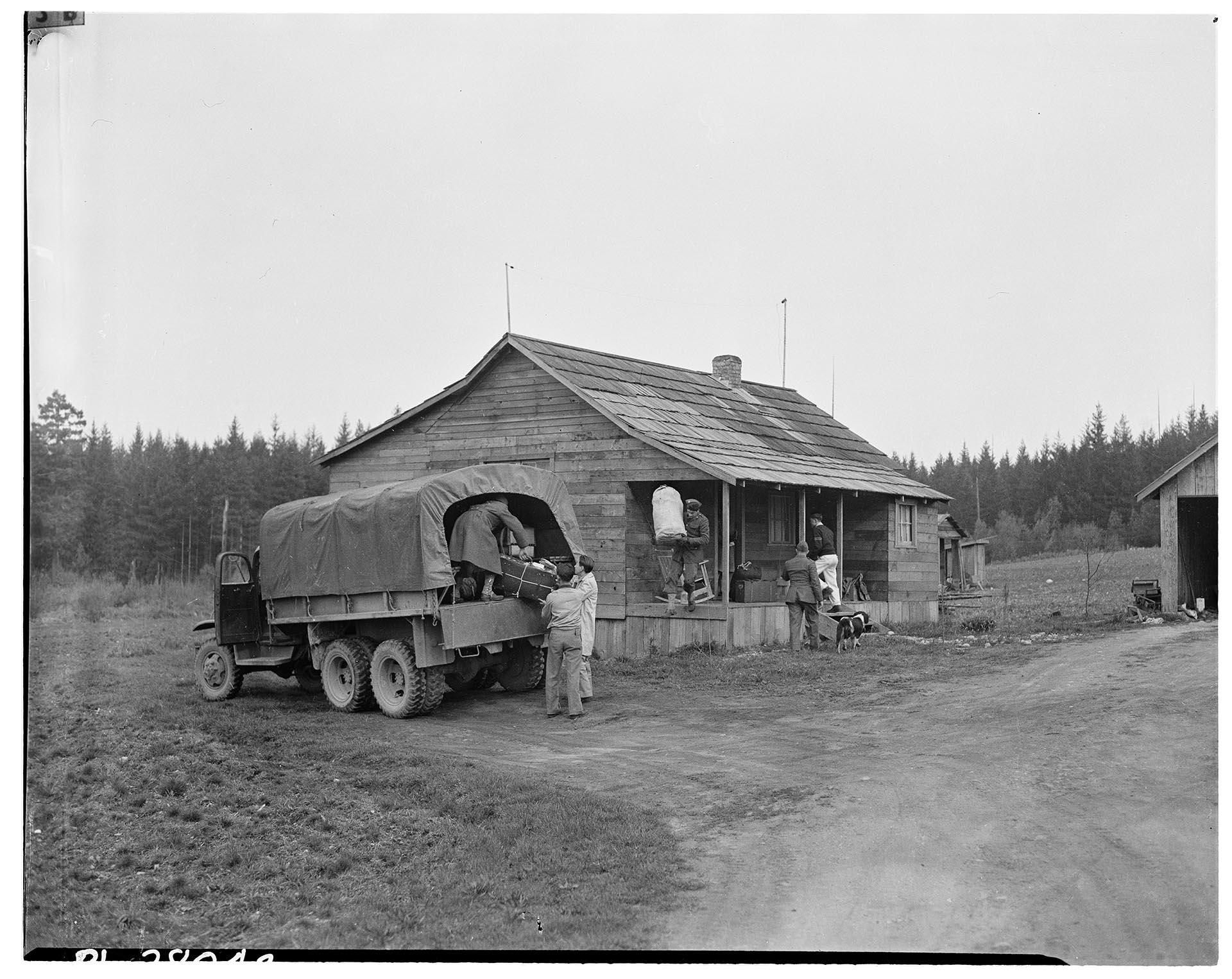 Image of U. S. soldiers and Japanese Americans loading Army truck for evacuation, Bainbridge Island, March 30, 1942