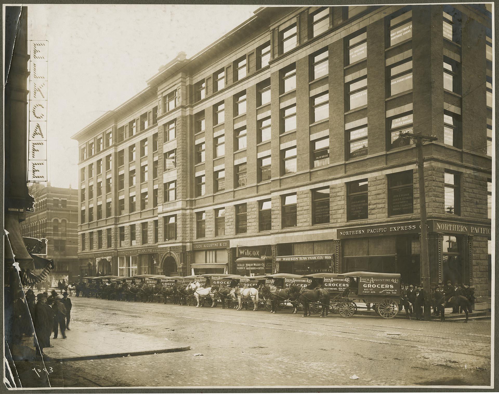 Image of Colman Building, with Lough, Augustine & Co.'s grocery wagons, Seattle, circa 1900