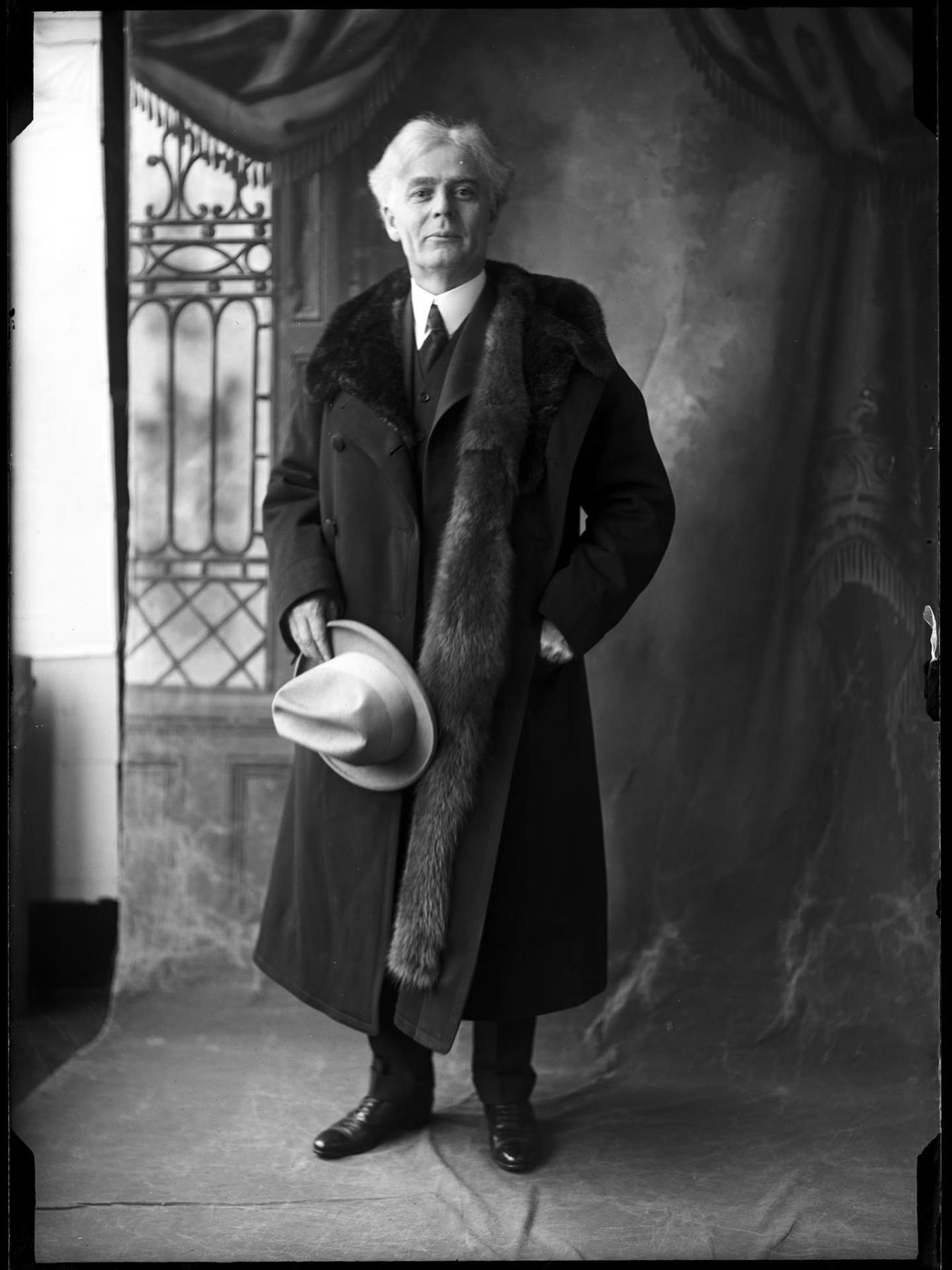 Image of Ole Hanson posing in suit and fur stole, Seattle, circa 1919
