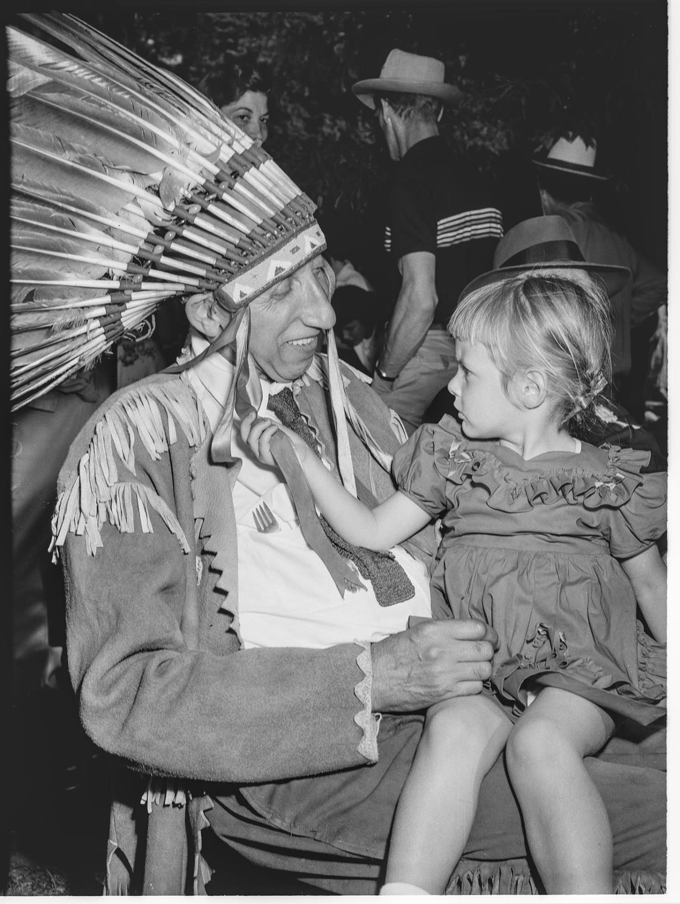 Image of Chief Yellow Lark with little girl on lap at Pow Wow, Seattle, August 20, 1950