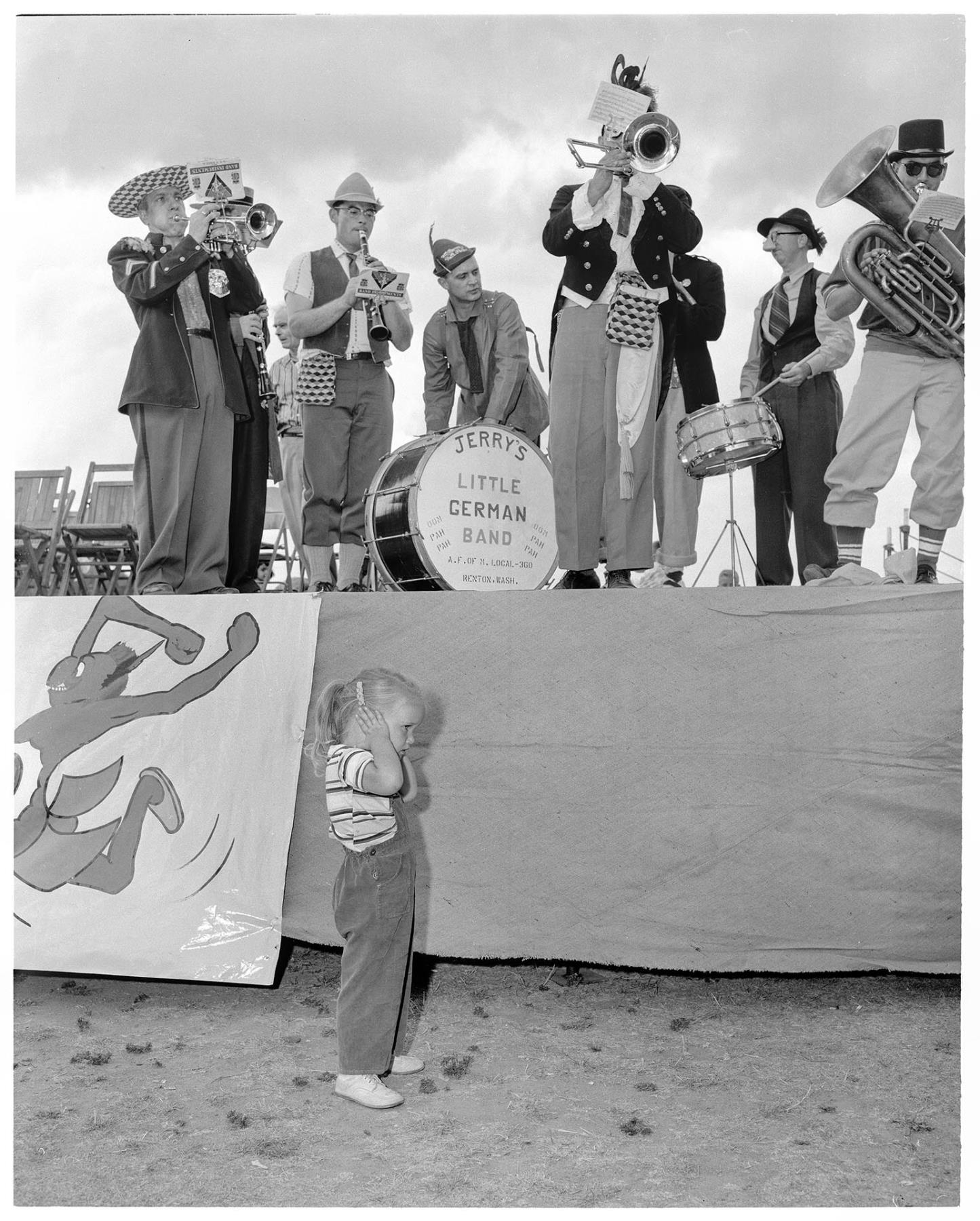 Image of Girl covering ears near band, Seattle, August 10, 1958
