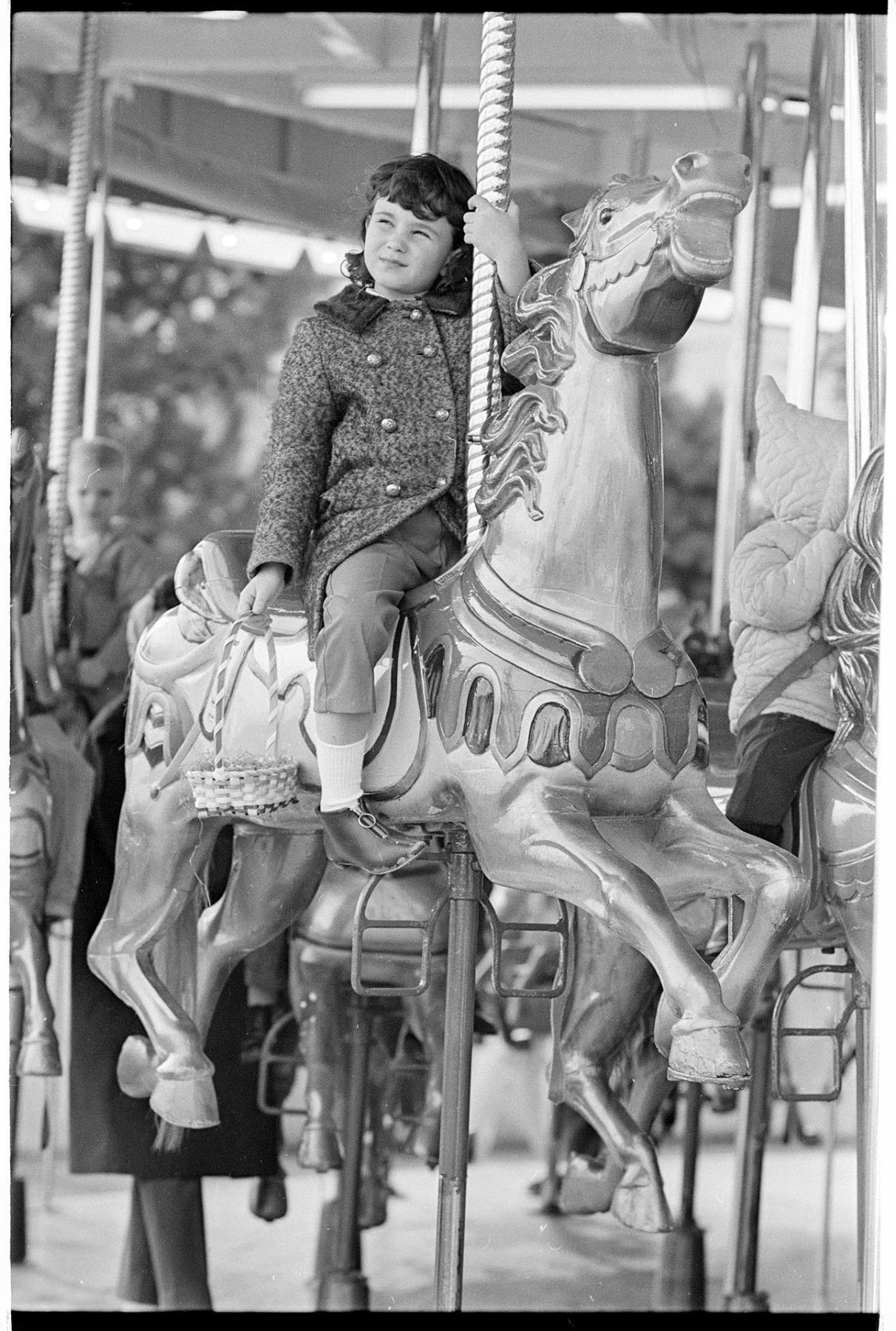 Image of Girl riding carousel at Fun Forest, Seattle Center, March 25, 1967