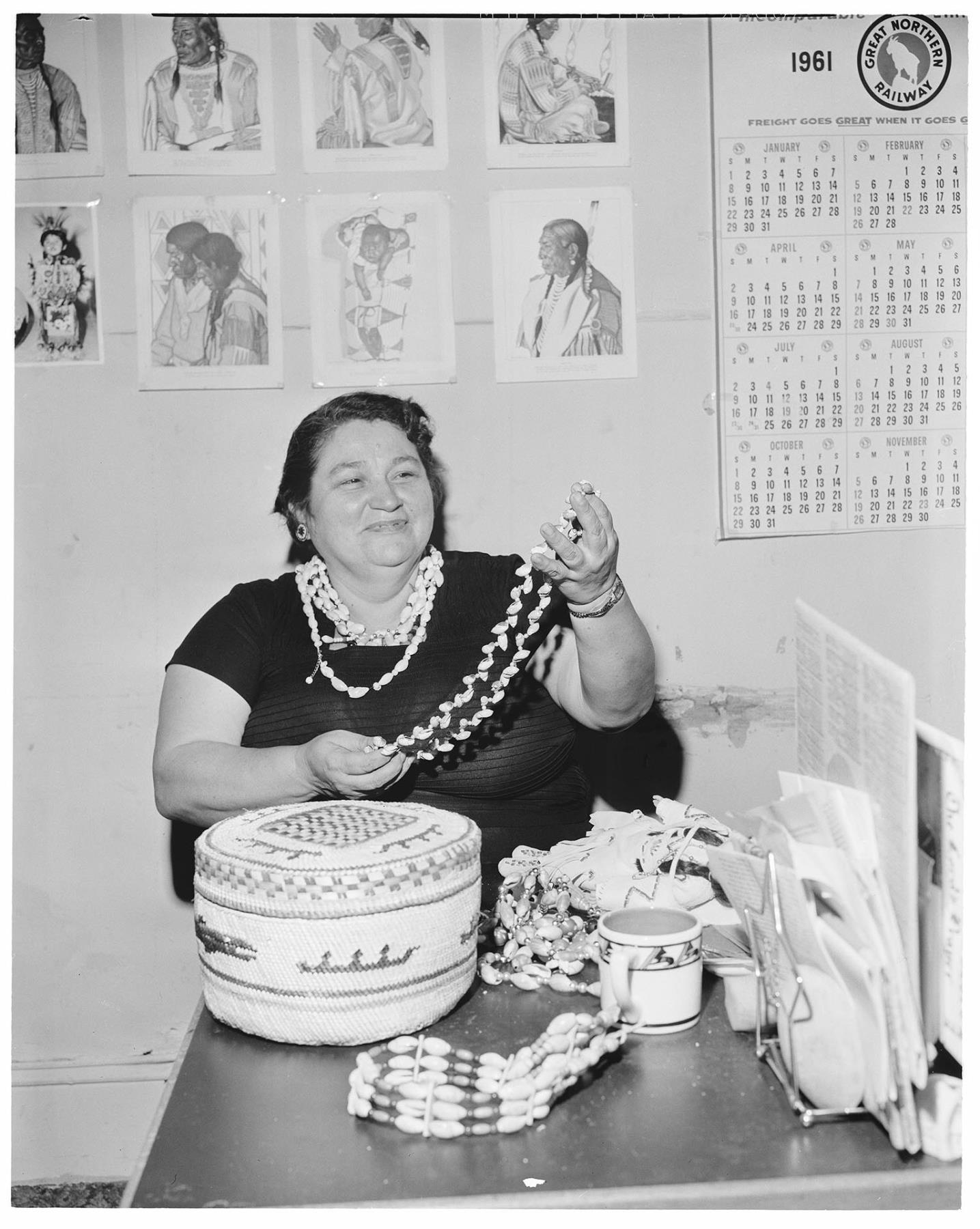 Image of AIWSL President Pearl Warren displaying Native American art, Seattle, January 1962