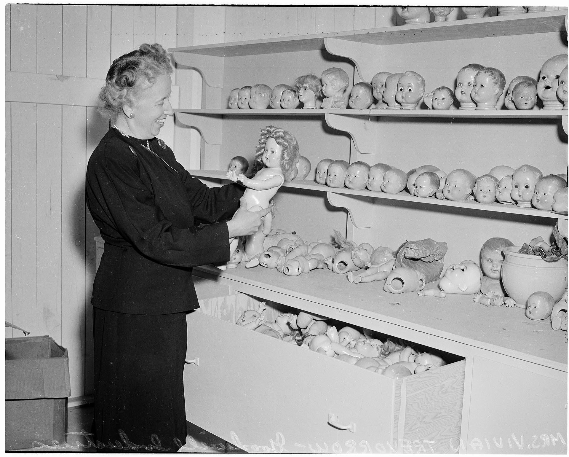 Image of Goodwill Auxiliary member sorting dolls, Seattle, November 2, 1958