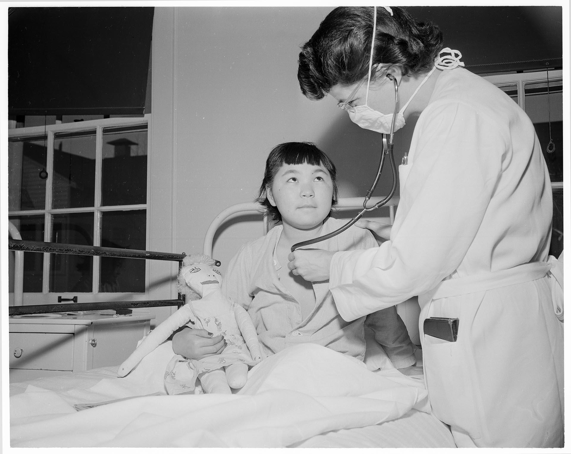 Image of Doctor examining young patient at Firland Sanatorium, Seattle, December 1, 1954