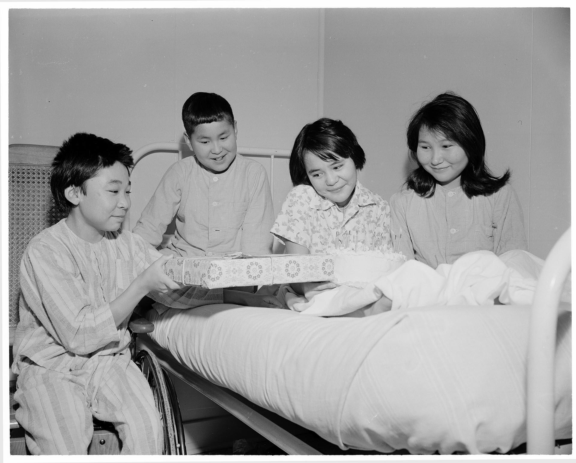 Image of Young patient giving another a gift at Firland Sanatorium, Seattle, December 1, 1954