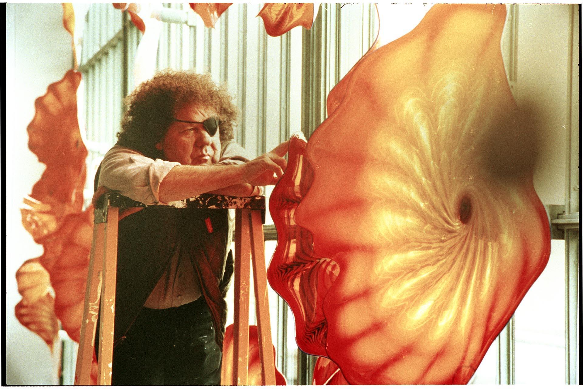 Image of Dale Chihuly adjusting glass sculpture, 1993