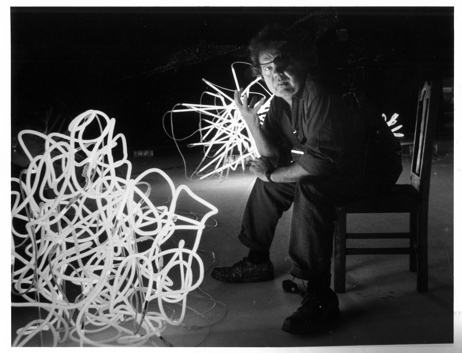 Image of Dale Chihuly sitting with neon 