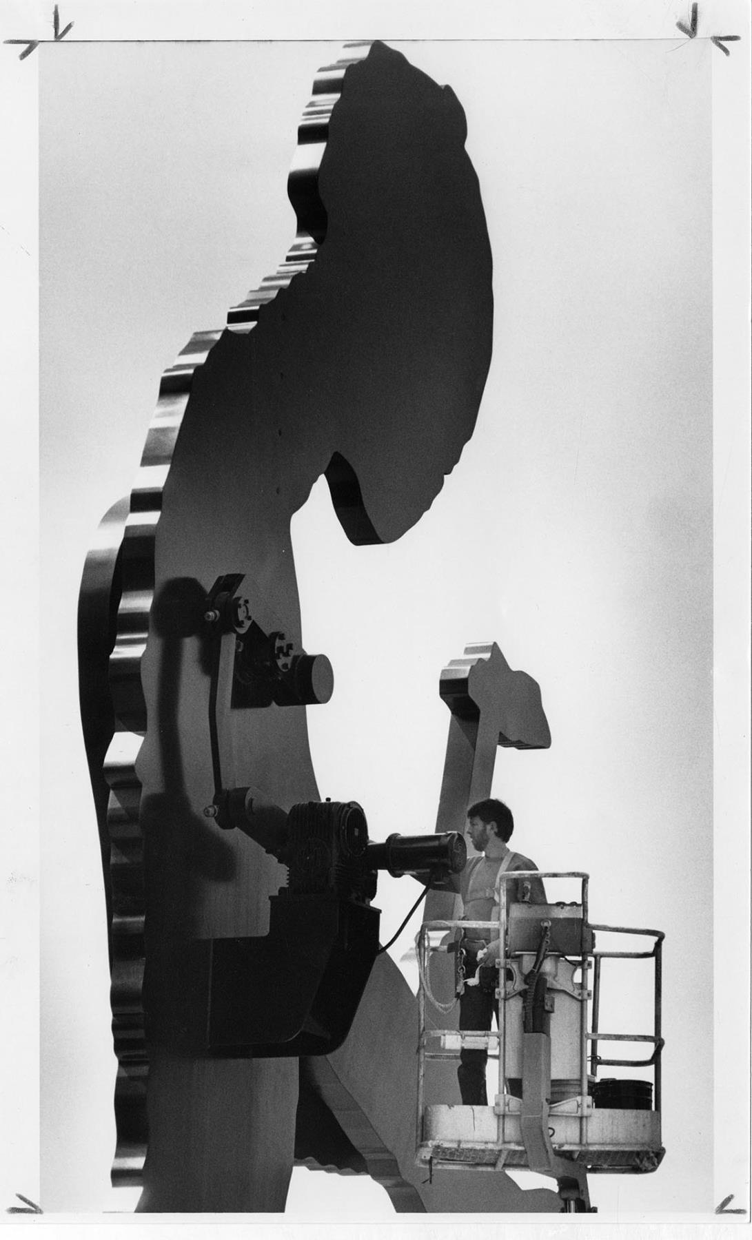 Image of Worker oiling motor for Hammering Man sculpture, Seattle, May 10, 1993