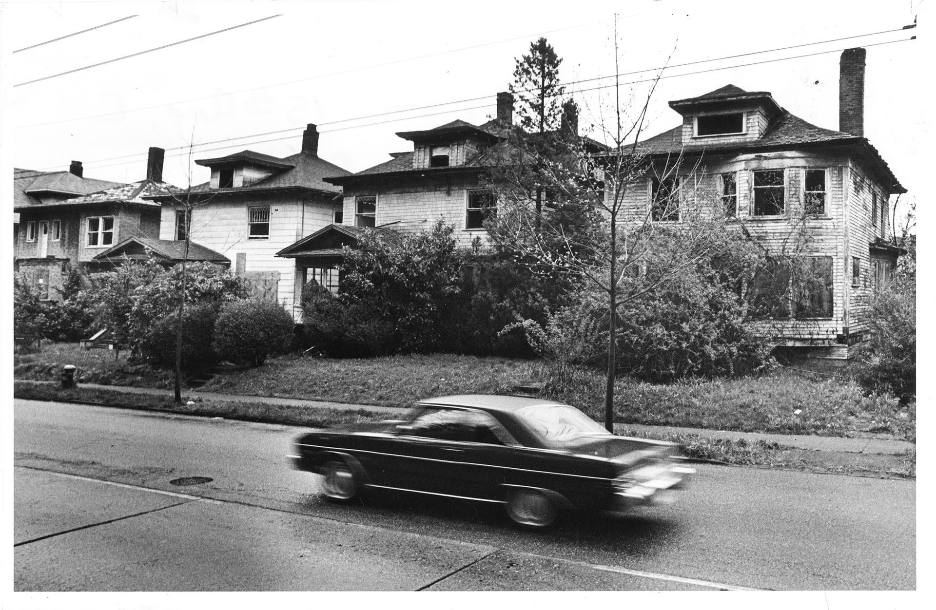 Image of Car passing vacant houses on Capitol Hill, Seattle, April 13, 1982