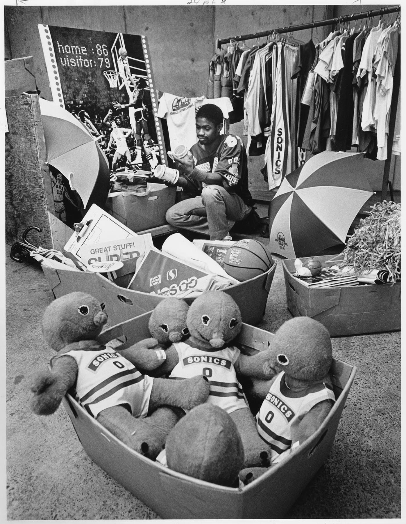 Image of K. C. Curry sorting Sonics souvenirs at Goodwill, Seattle, February 6, 1987