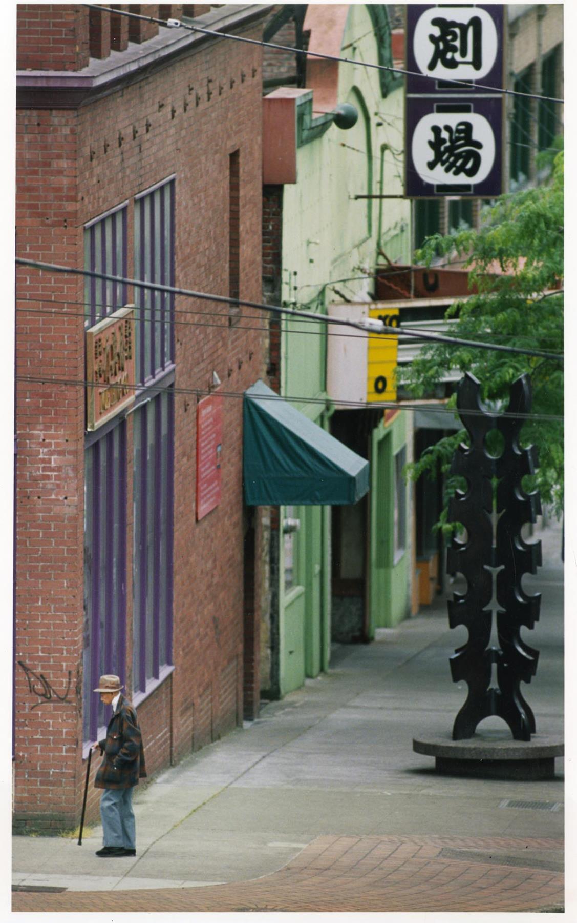 Image of Man walking past Tsutakawa sculpture in Chinatown - International District, Seattle June 29, 1988
