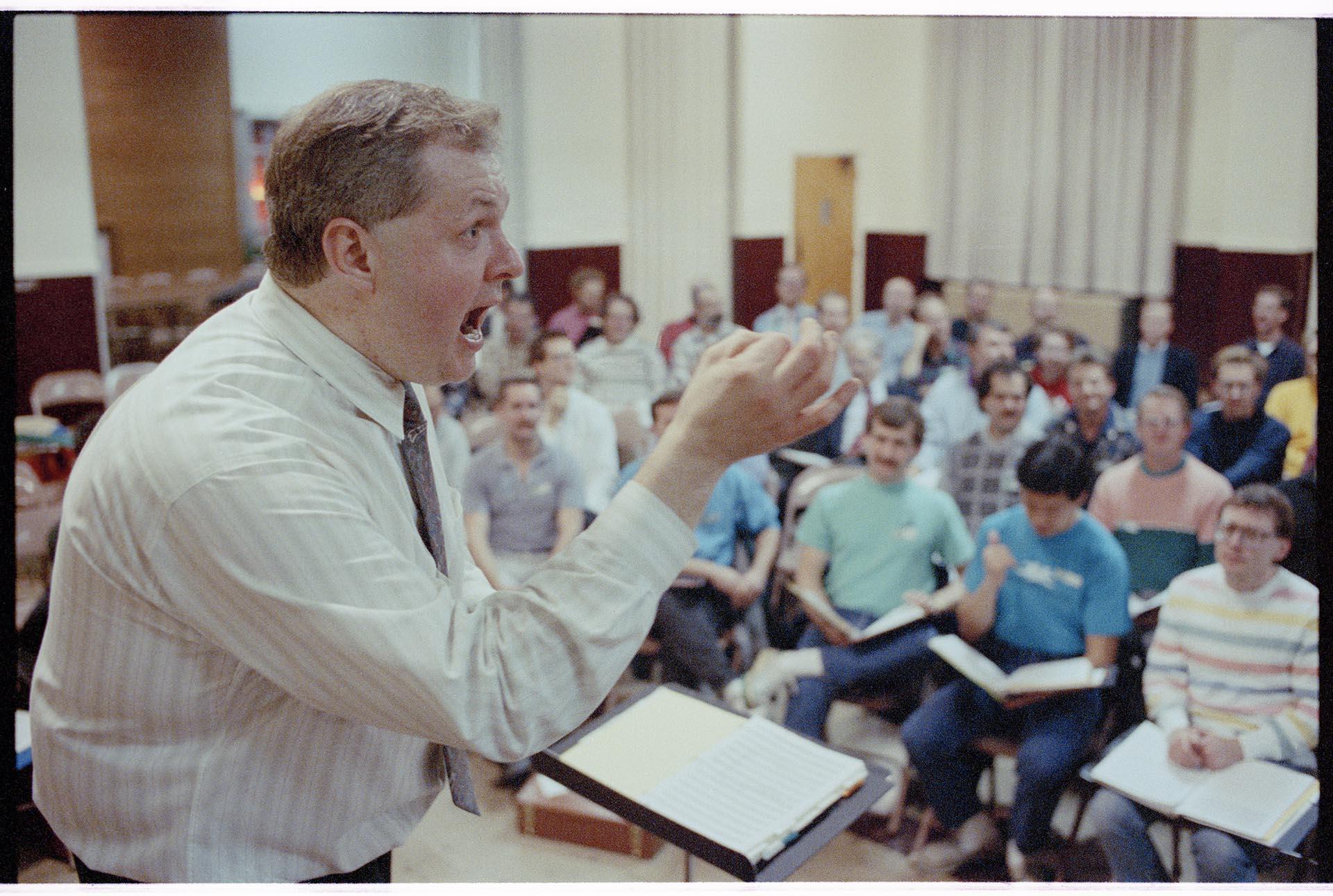 Image of Dennis Coleman conducting Seattle Men's Chorus rehearsal, November 26, 1990