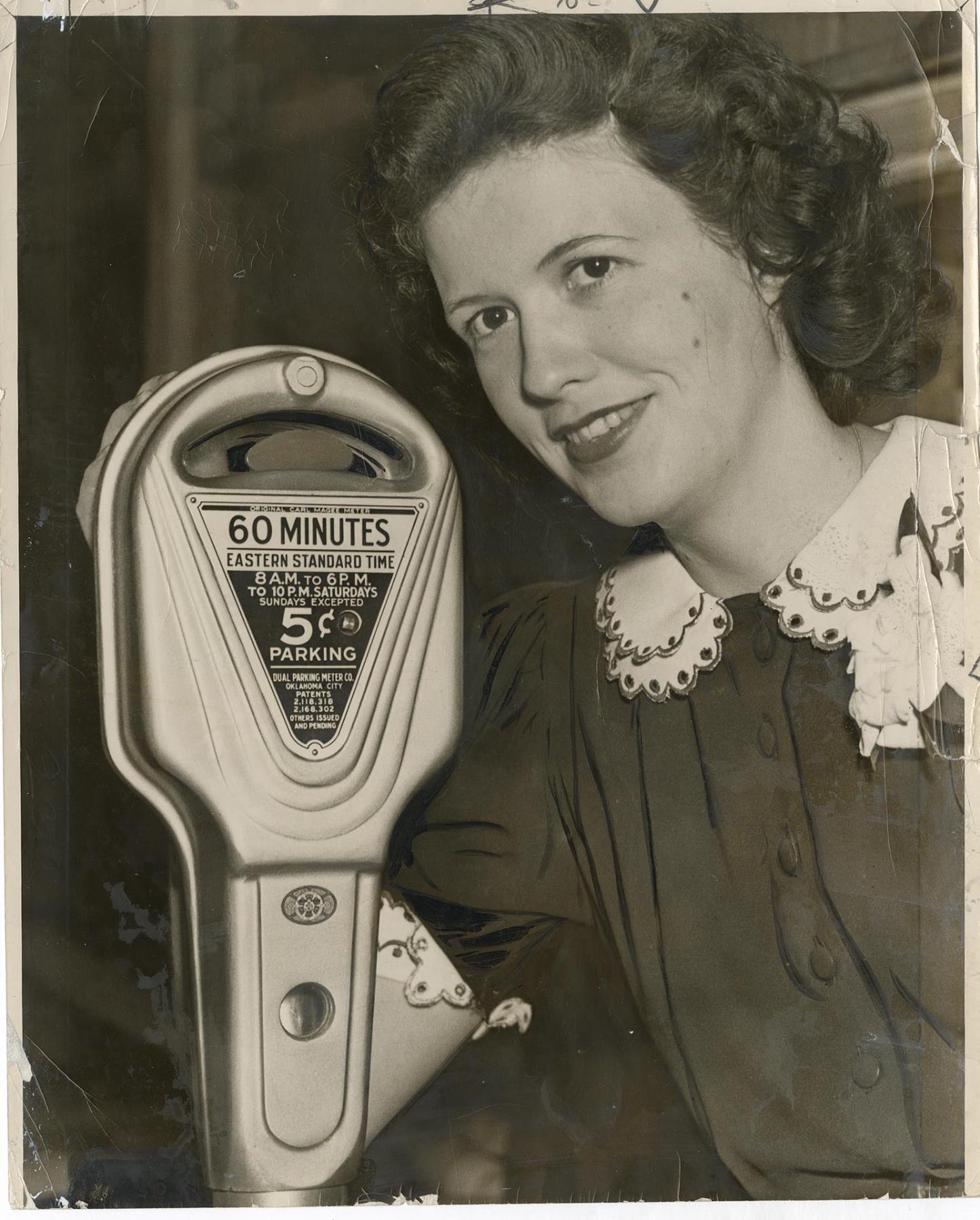 Image of Jane Abernathy posing with new parking meter, July 11, 1941