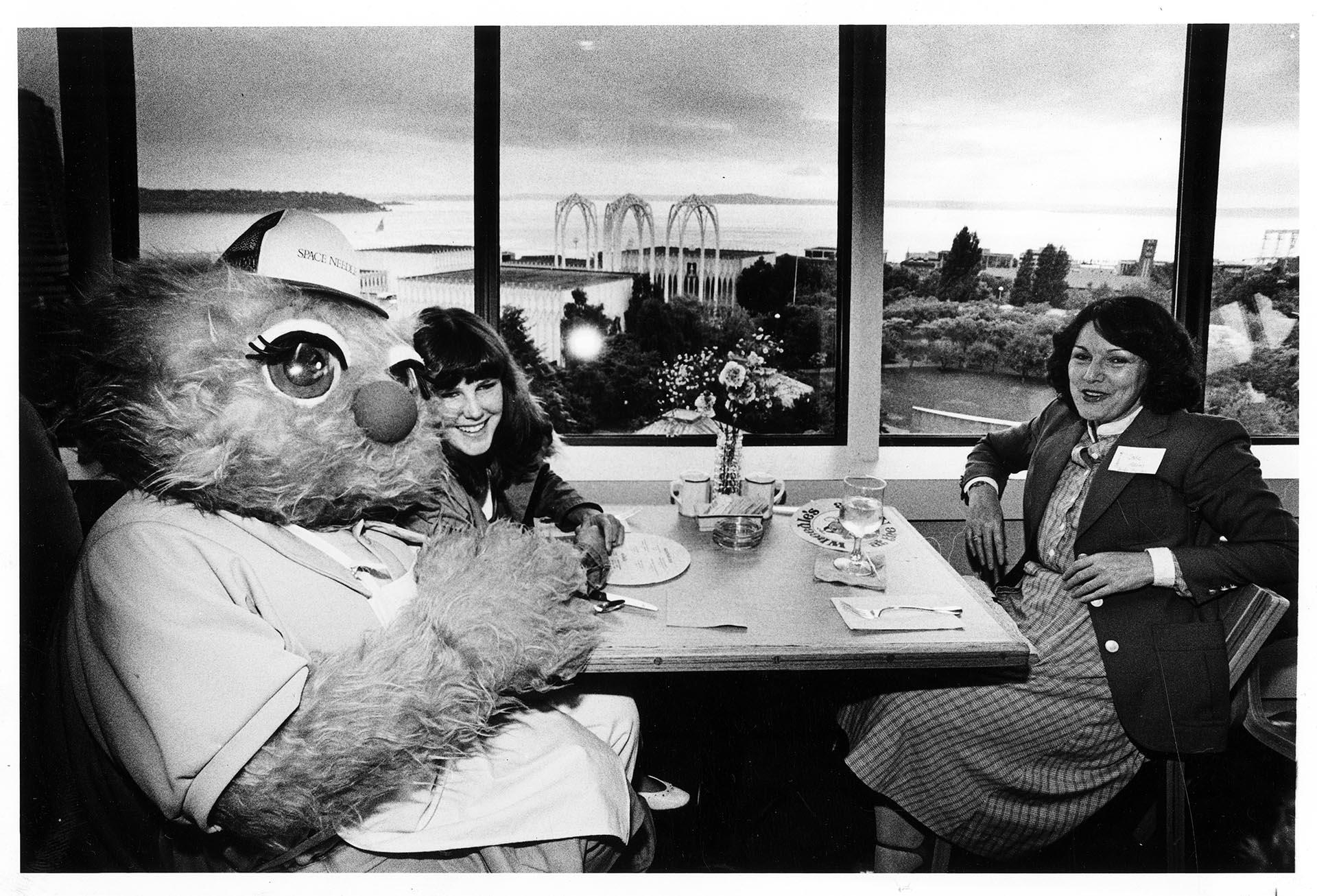 Image of Wheedle sitting with diners at the Space Needle, Seattle, July 19, 1982