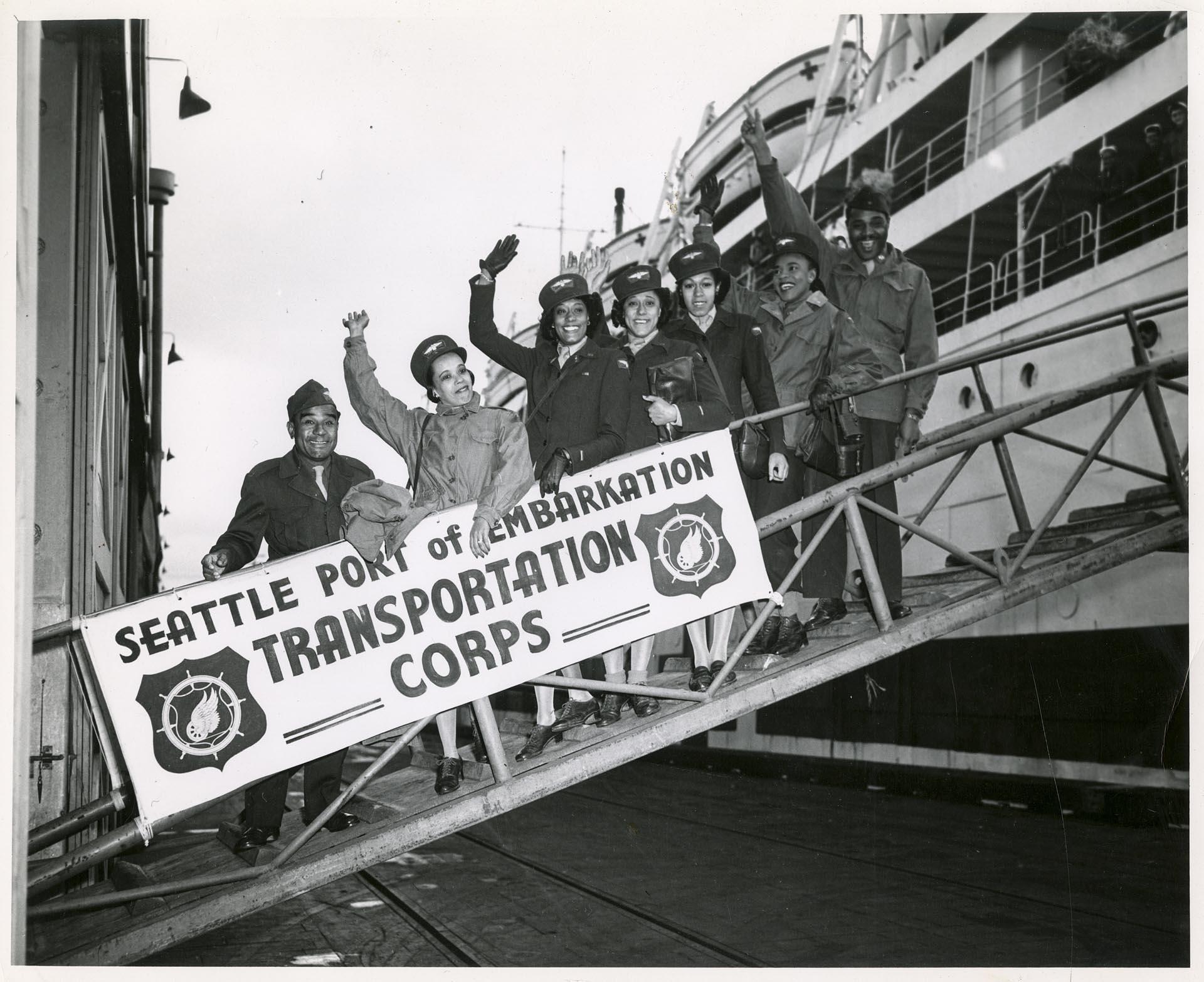 Image of Soldiers waving from gangplank at Port of Embarkation, Seattle, circa 1944