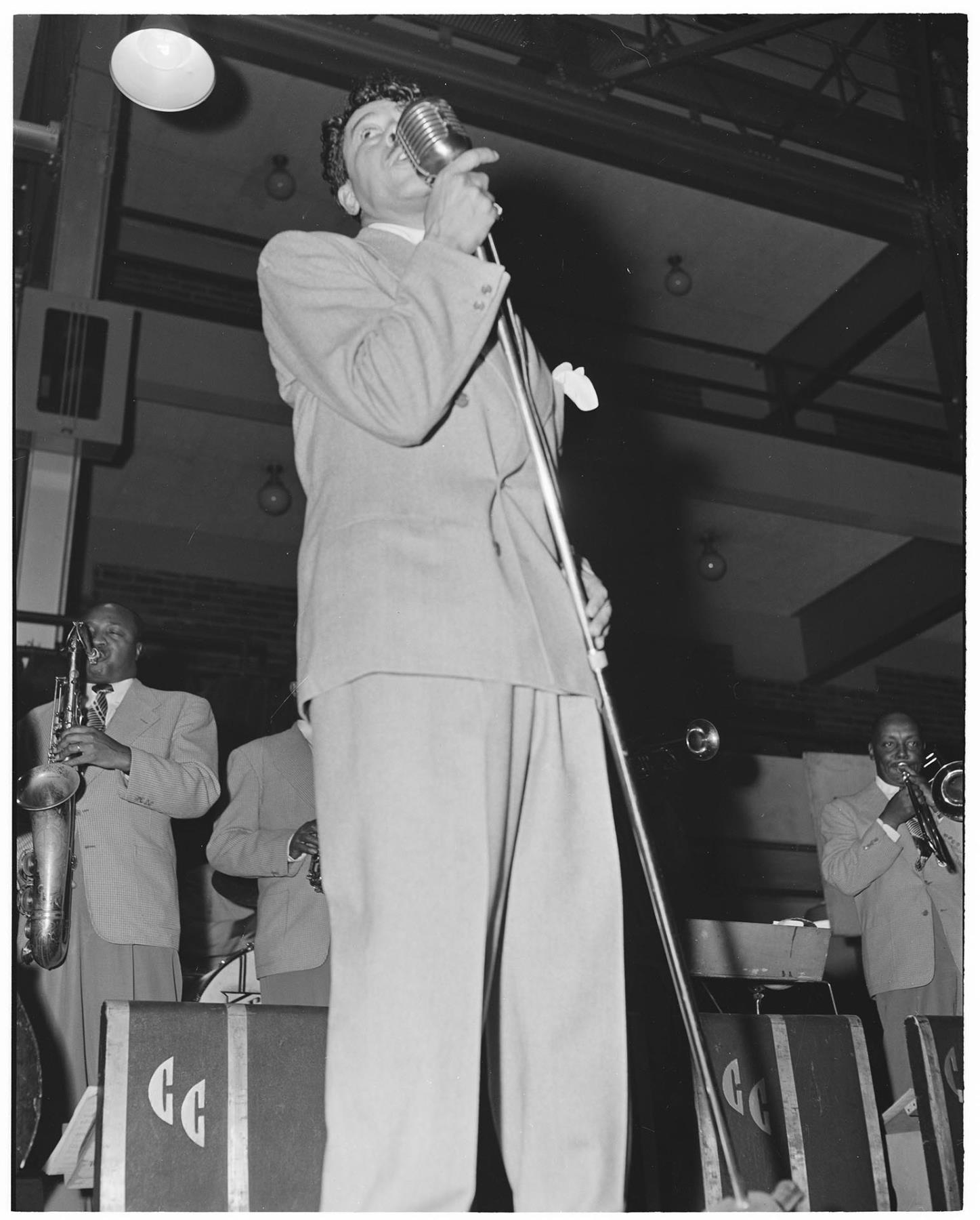 Image of Cab Calloway singing on stage with his orchestra, circa 1947