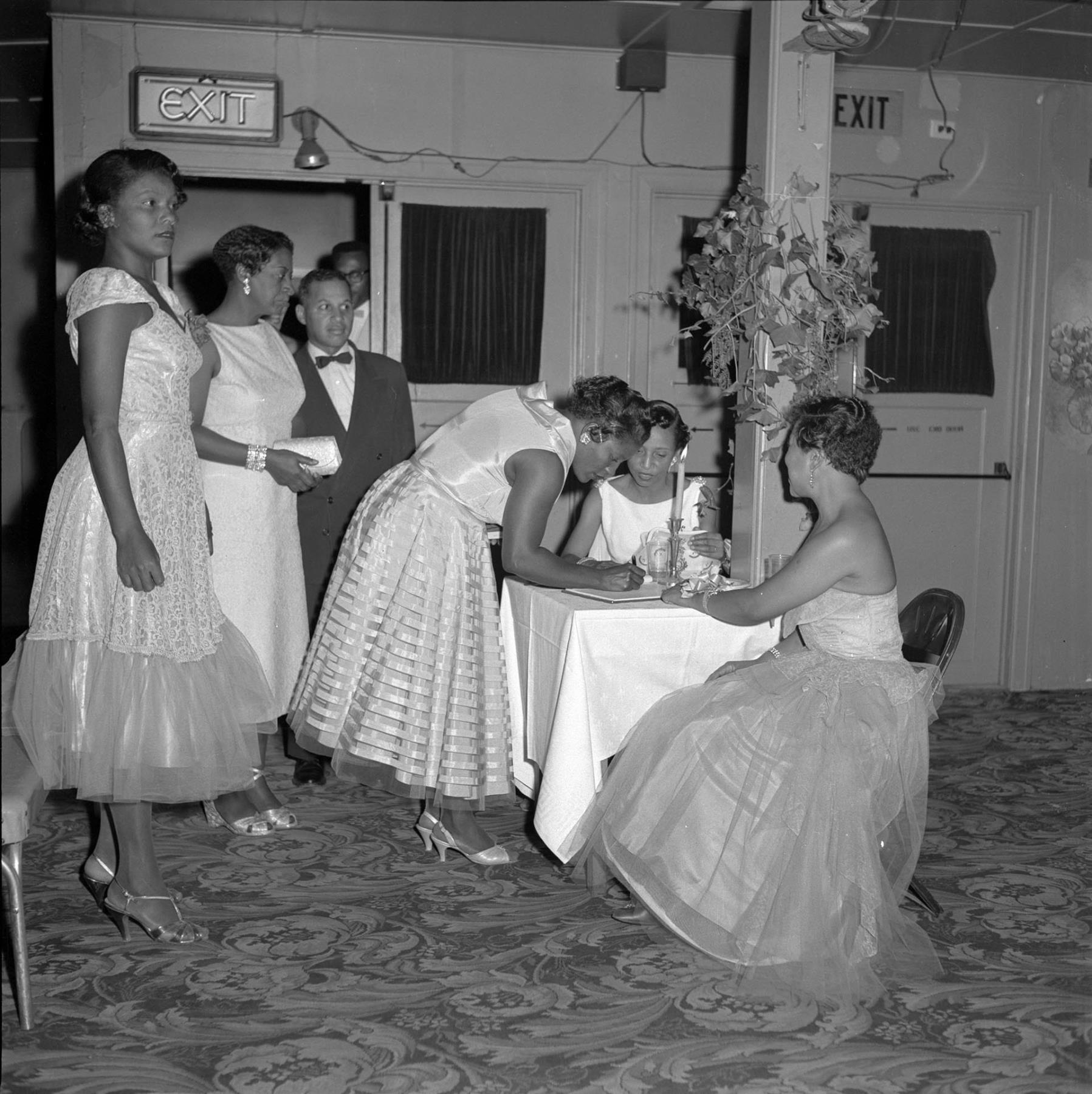 Image of Janice Fair and friends signing guestbook, Seattle, circa 1953