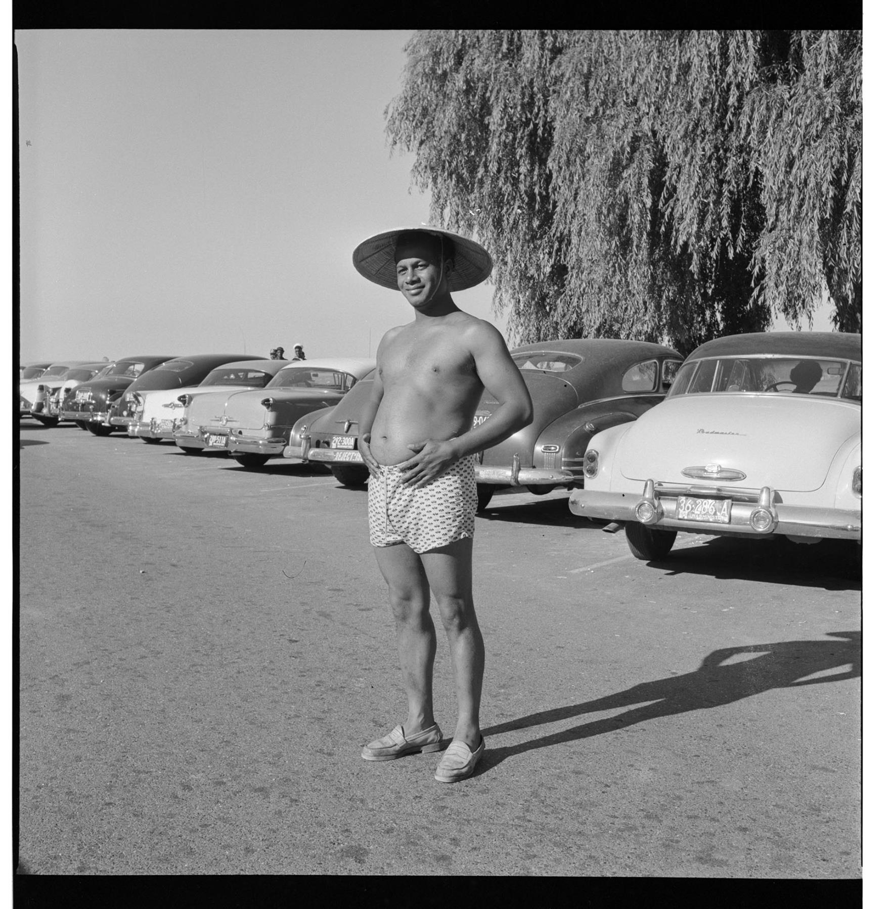 Image of Jason Gayle standing in parking lot in bathing suit and hat, Seattle, circa 1953