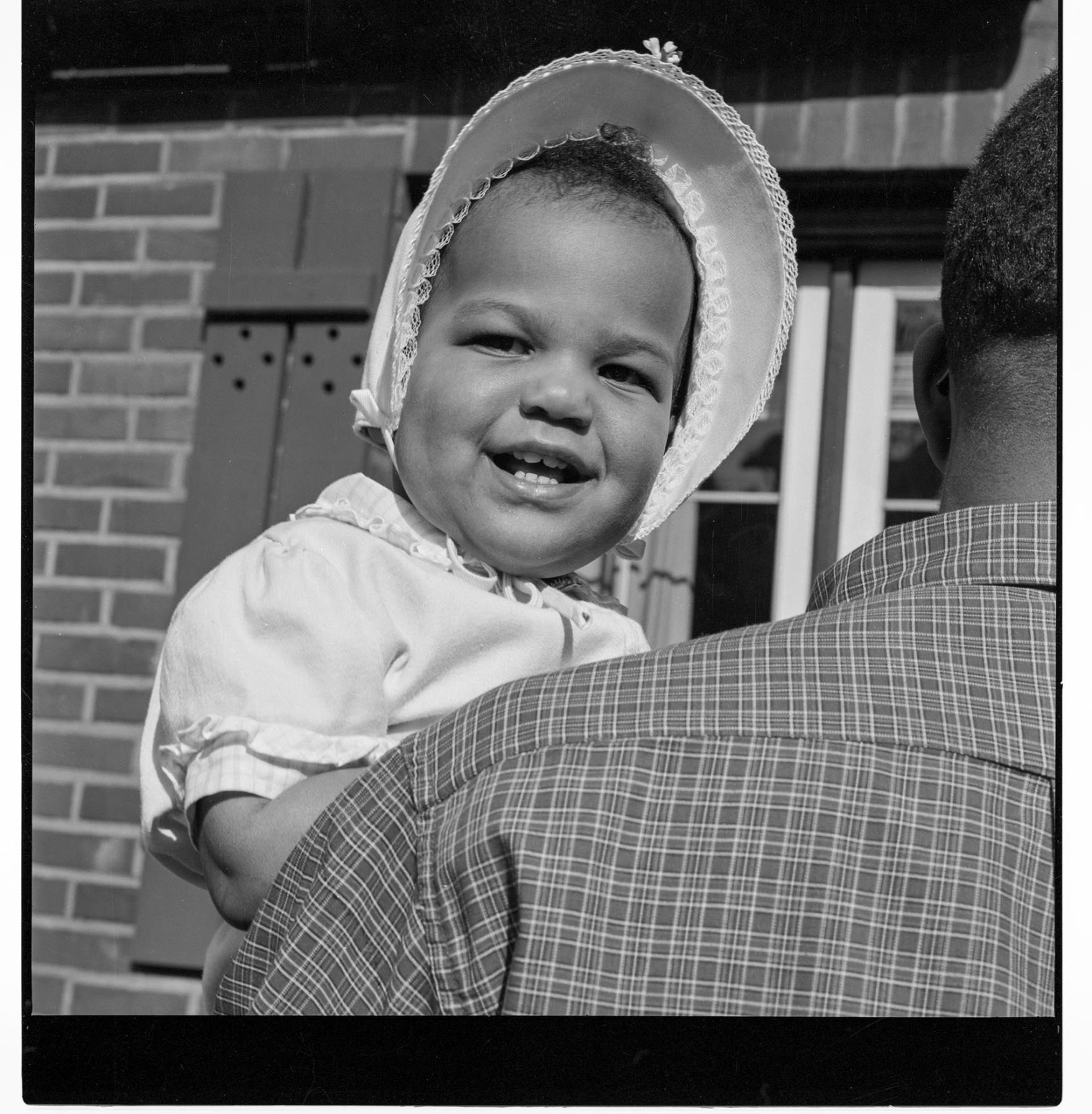 Image of Carol Peoples looking over her father's shoulder, Seattle, circa 1953