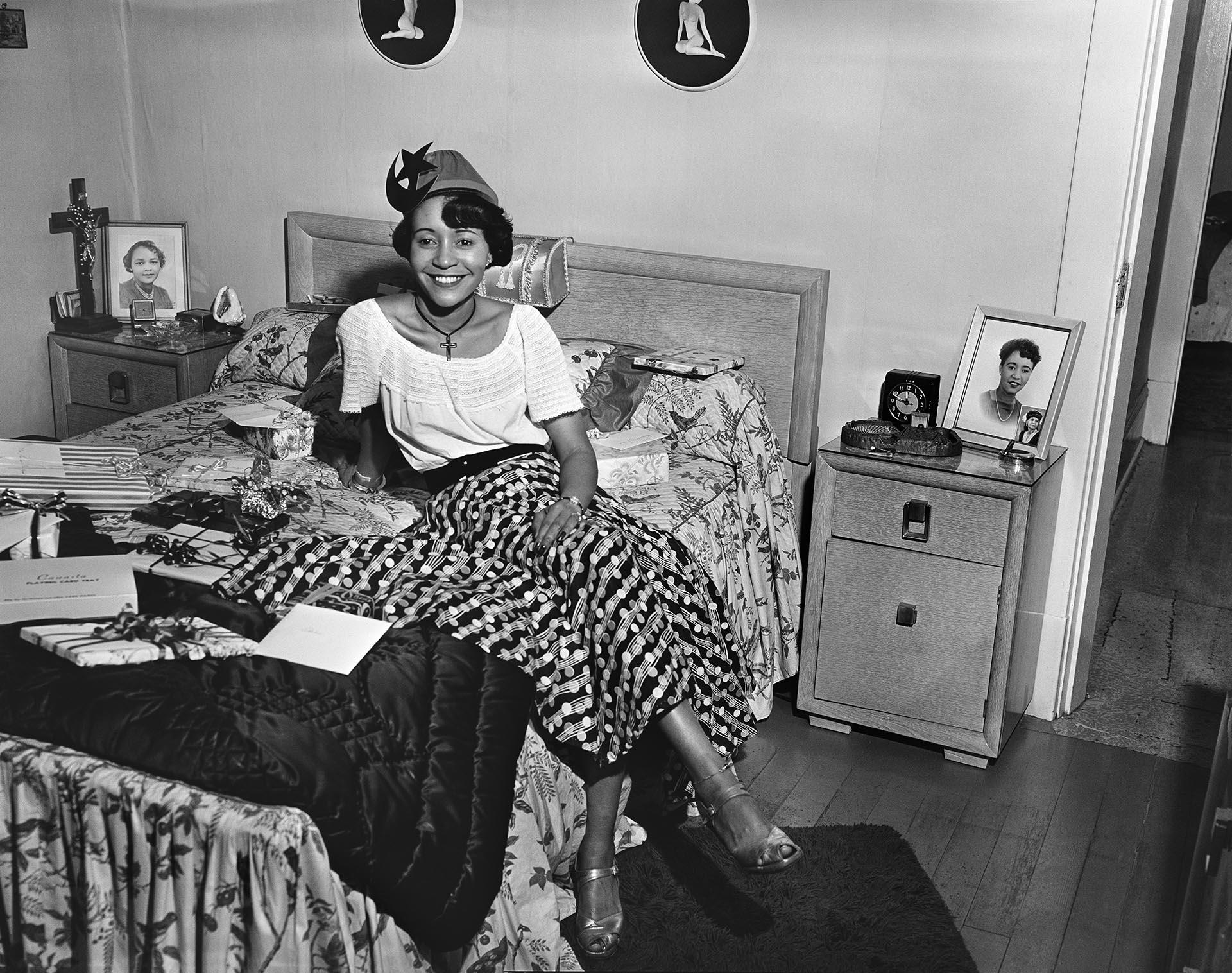 Image of Woman wearing party hat sitting on bed, Seattle, circa 1950