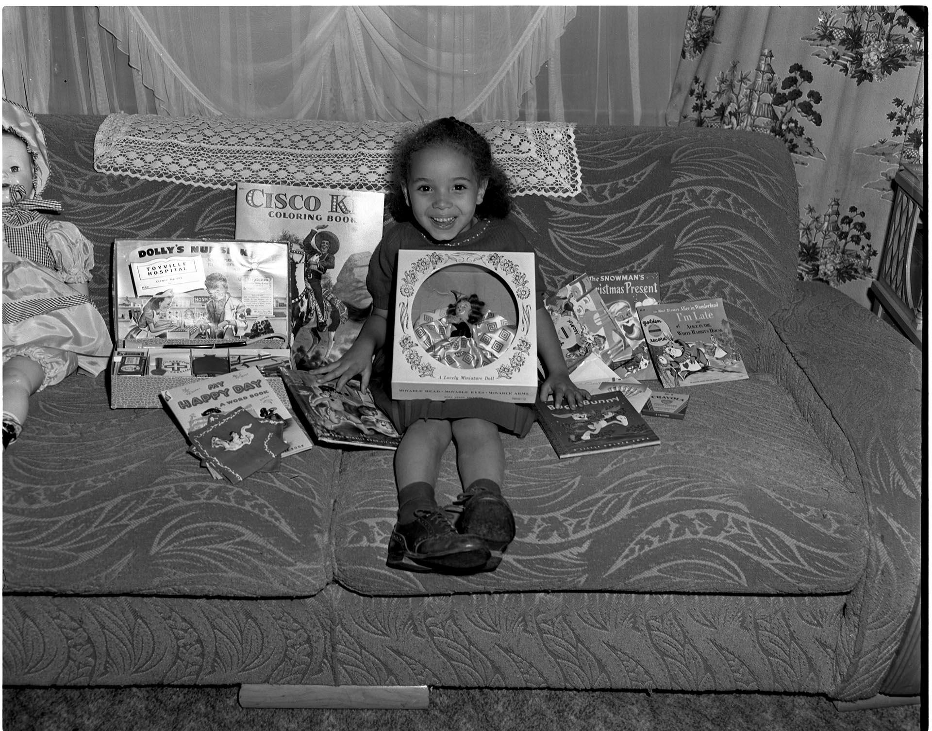 Image of Girl on couch with  presents, Seattle, circa 1953