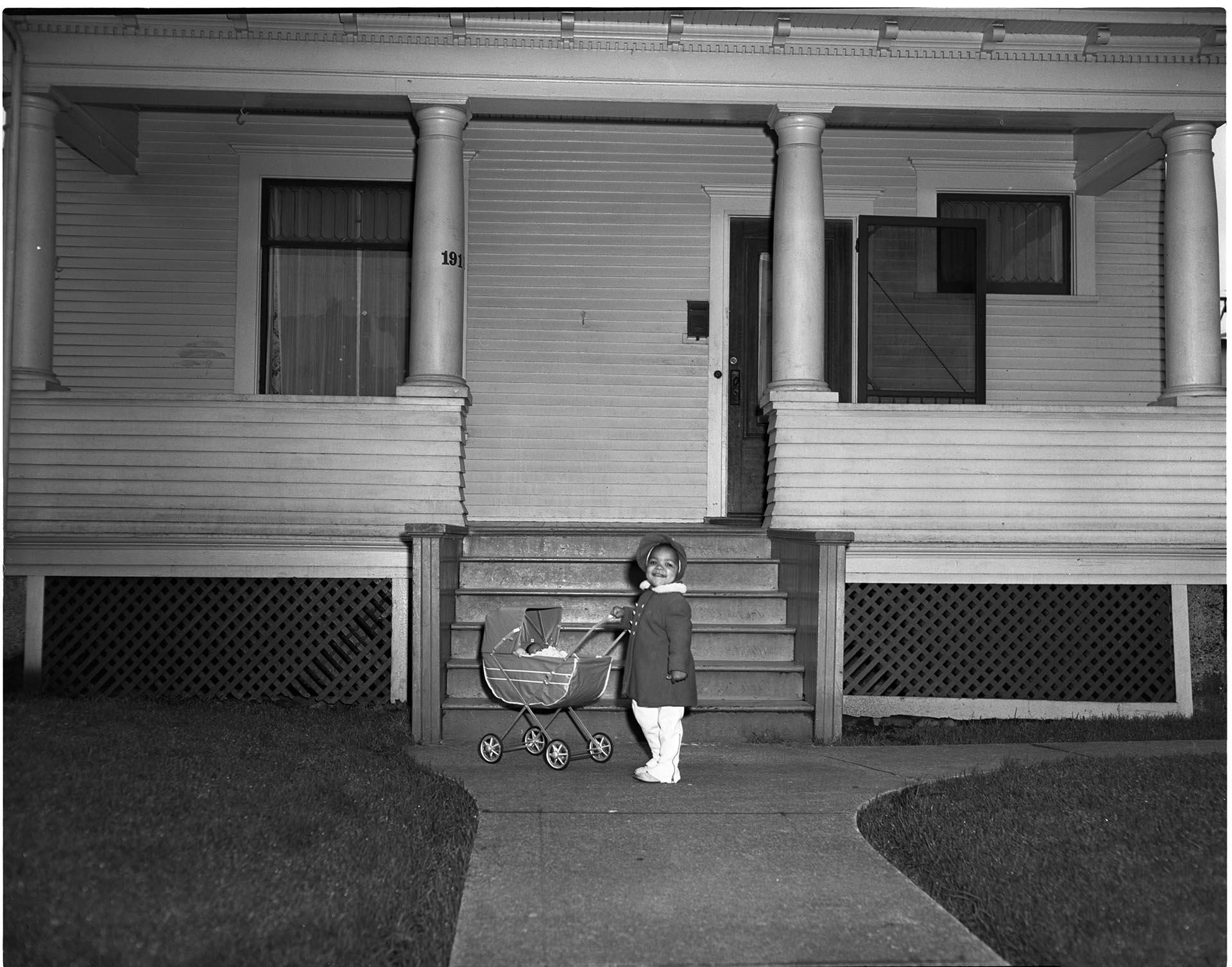 Image of Girl with doll carriage in front of house, Seattle, circa 1953