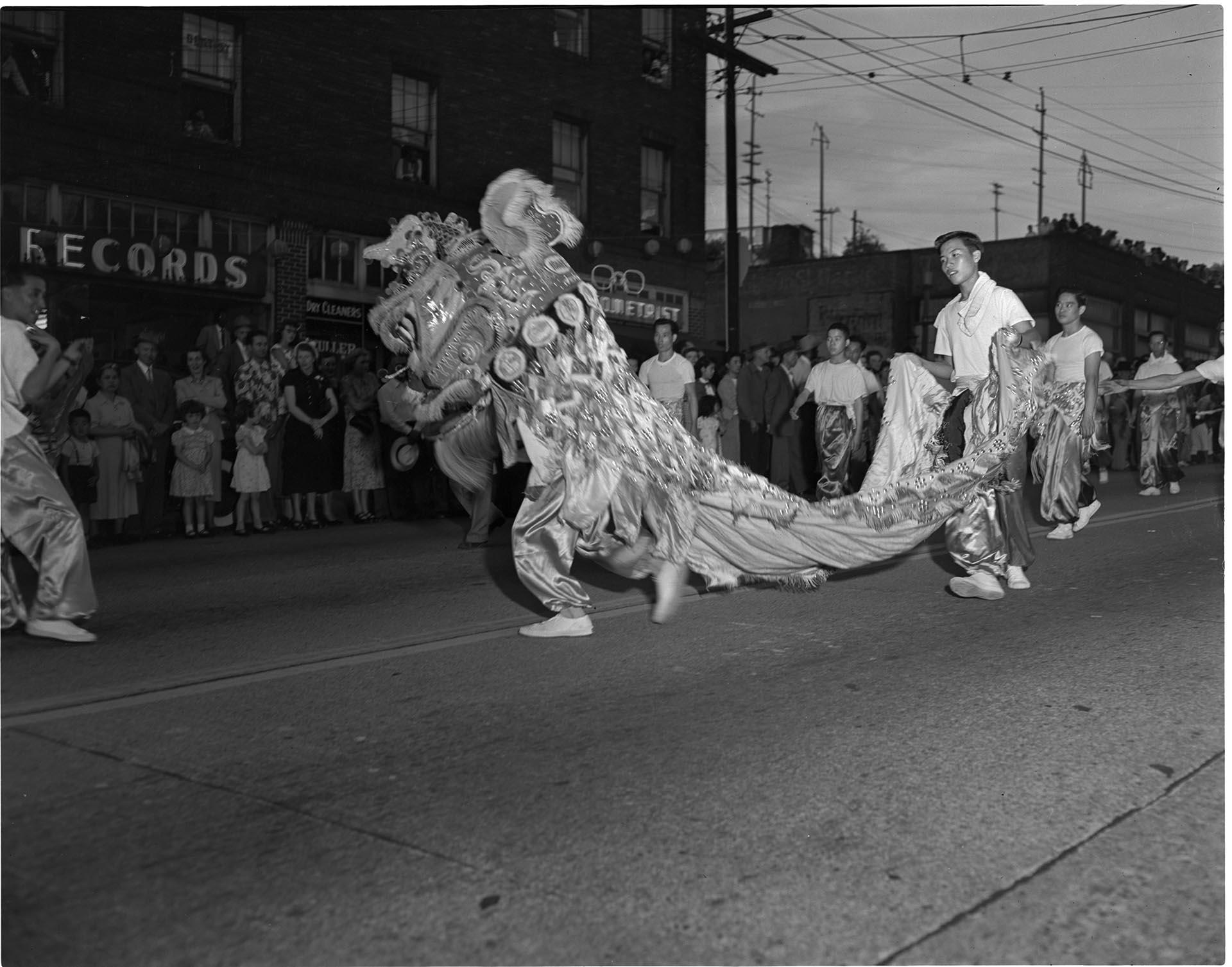 Image of Chinese dancers performing in a parade, Seattle, circa 1953