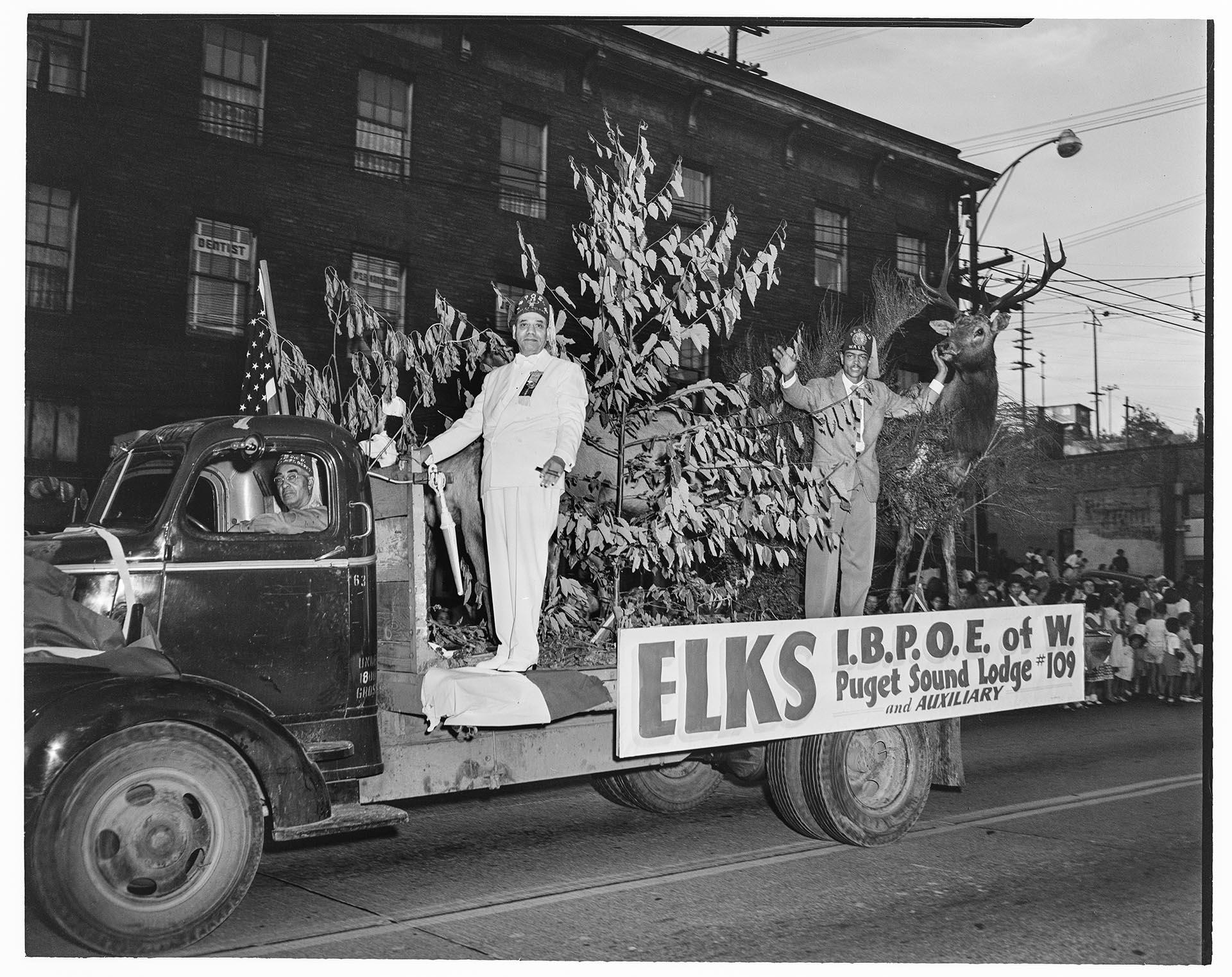 Image of Men waving on Elks parade float, Seattle, April  9, 1950