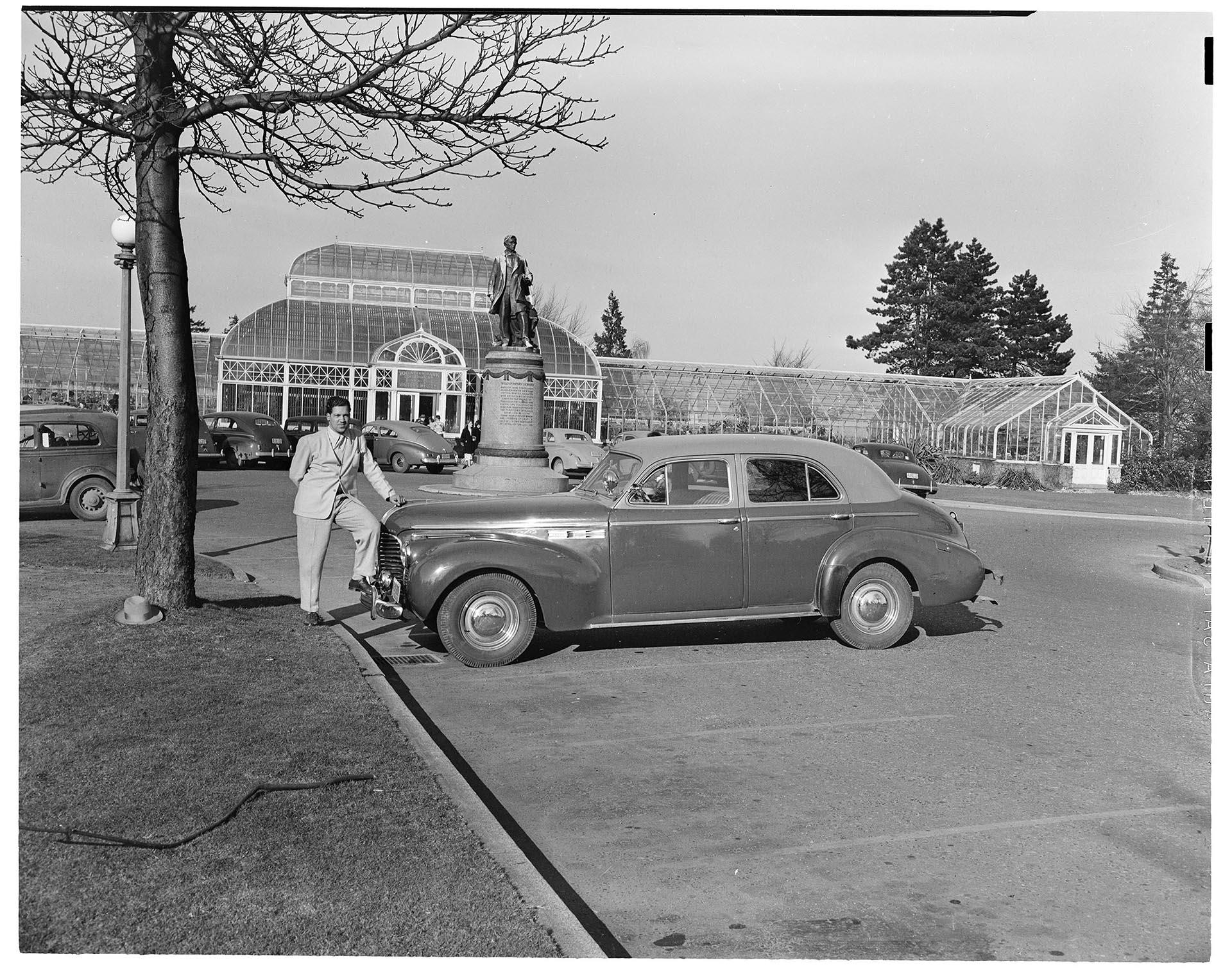 Image of Don Alexander with car at Volunteer Park Conservatory, Seattle, February 9, 1947