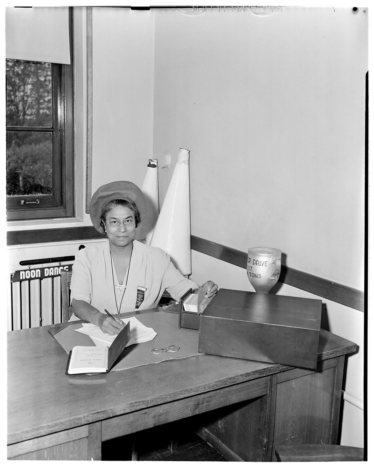 Image of NACWC Executive Secretary Ruby Kendrick seated at desk, Seattle, August 1948