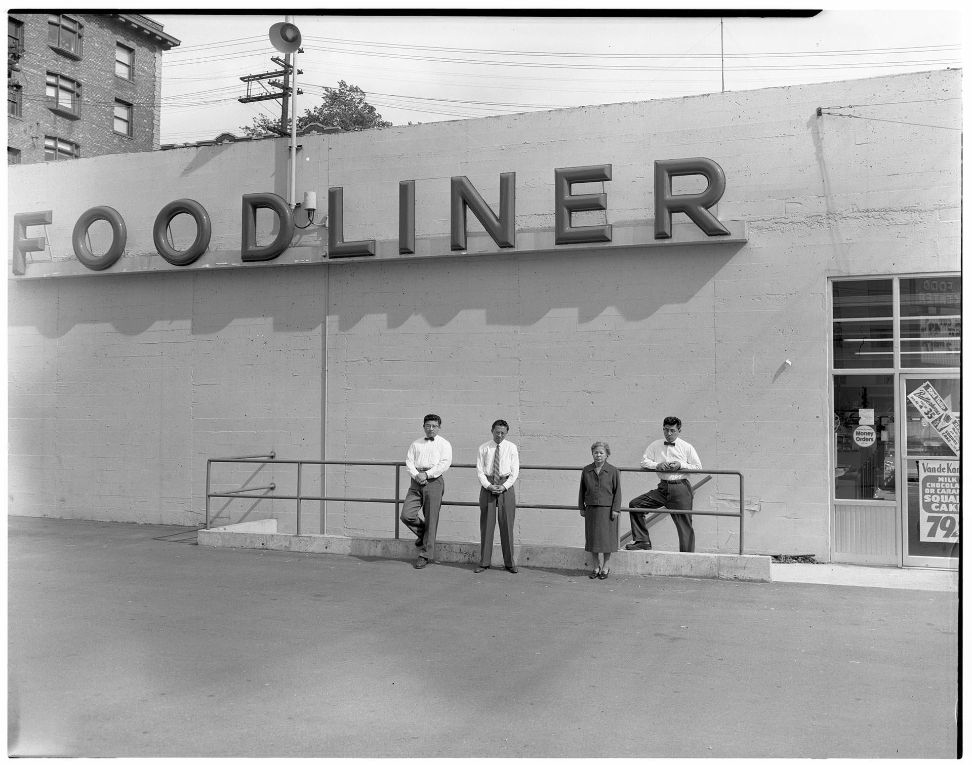 Image of Kimura family posing in front of their store, Seattle, circa 1953