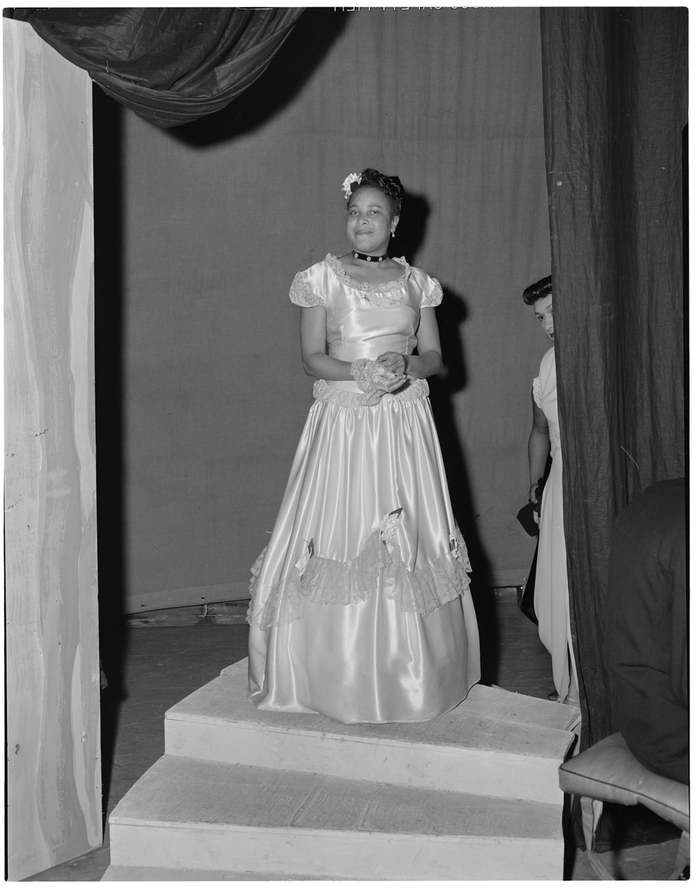 Image of Lillian Gideon modeling gown at fashion show, Seattle, circa 1953