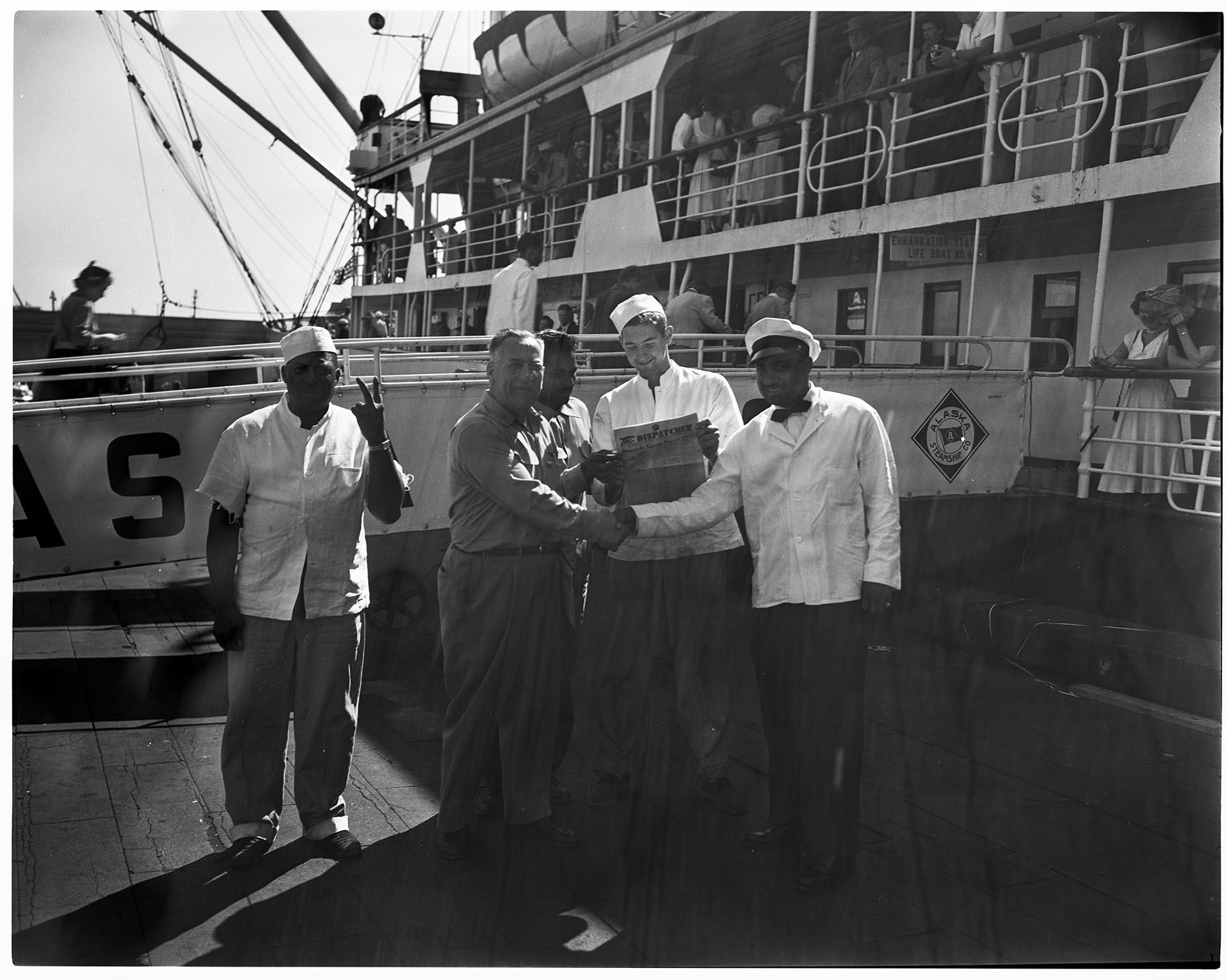Image of Men shaking hands on a dock in front of a ship, Seattle, circa 1953